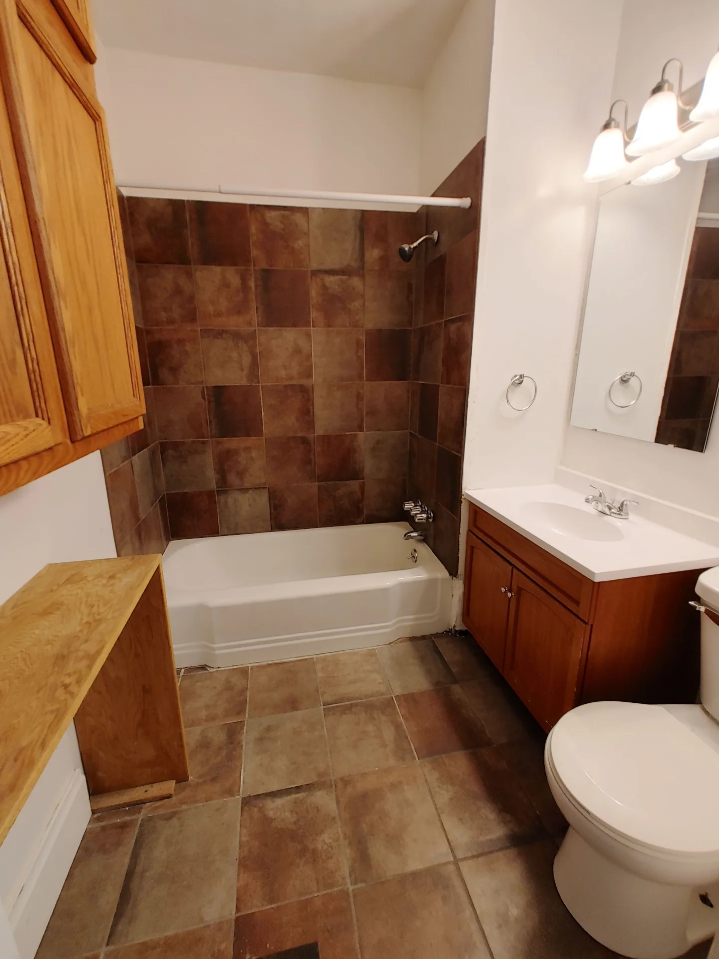 374 A E 14th Ave. bathroom with soaking tub, brown tile surround, and wood vanity