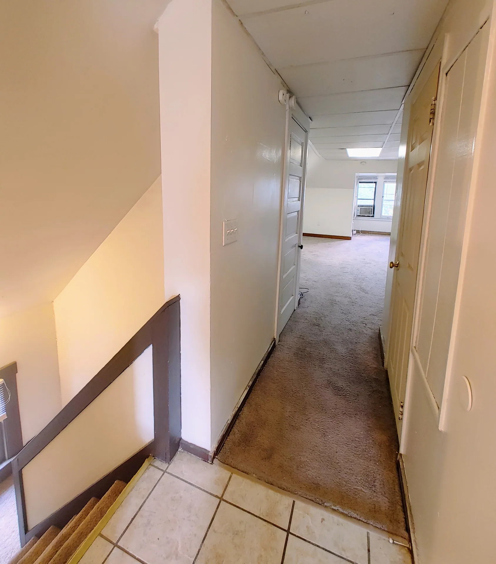 89 E Woodruff Ave. Unit C interior hallway with tile entry, private stairwell, and access to carpeted rooms