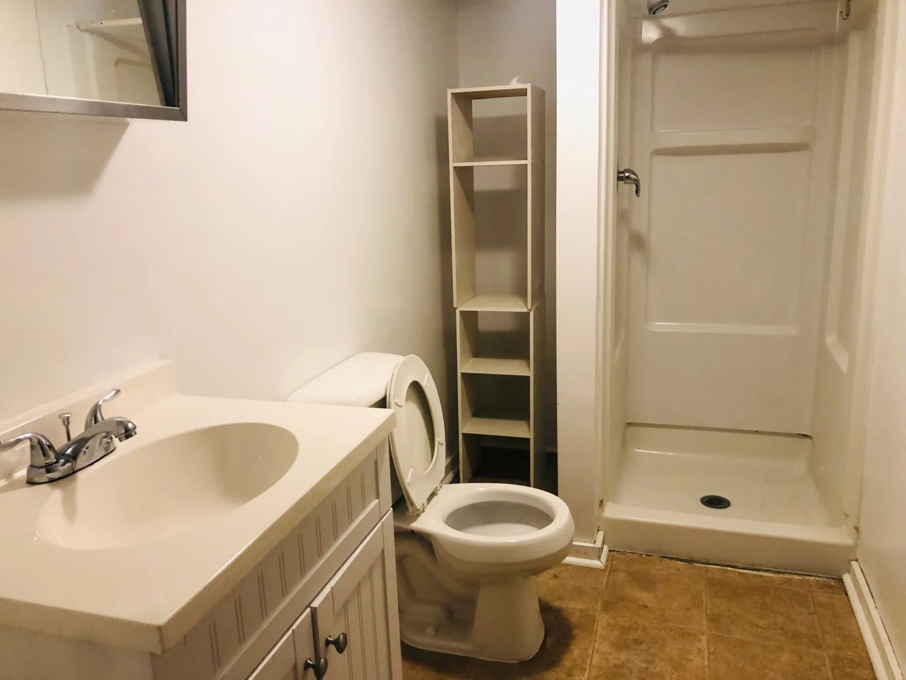 2015 Summit St. bathroom with white vanity, toilet, and stand-up shower stall