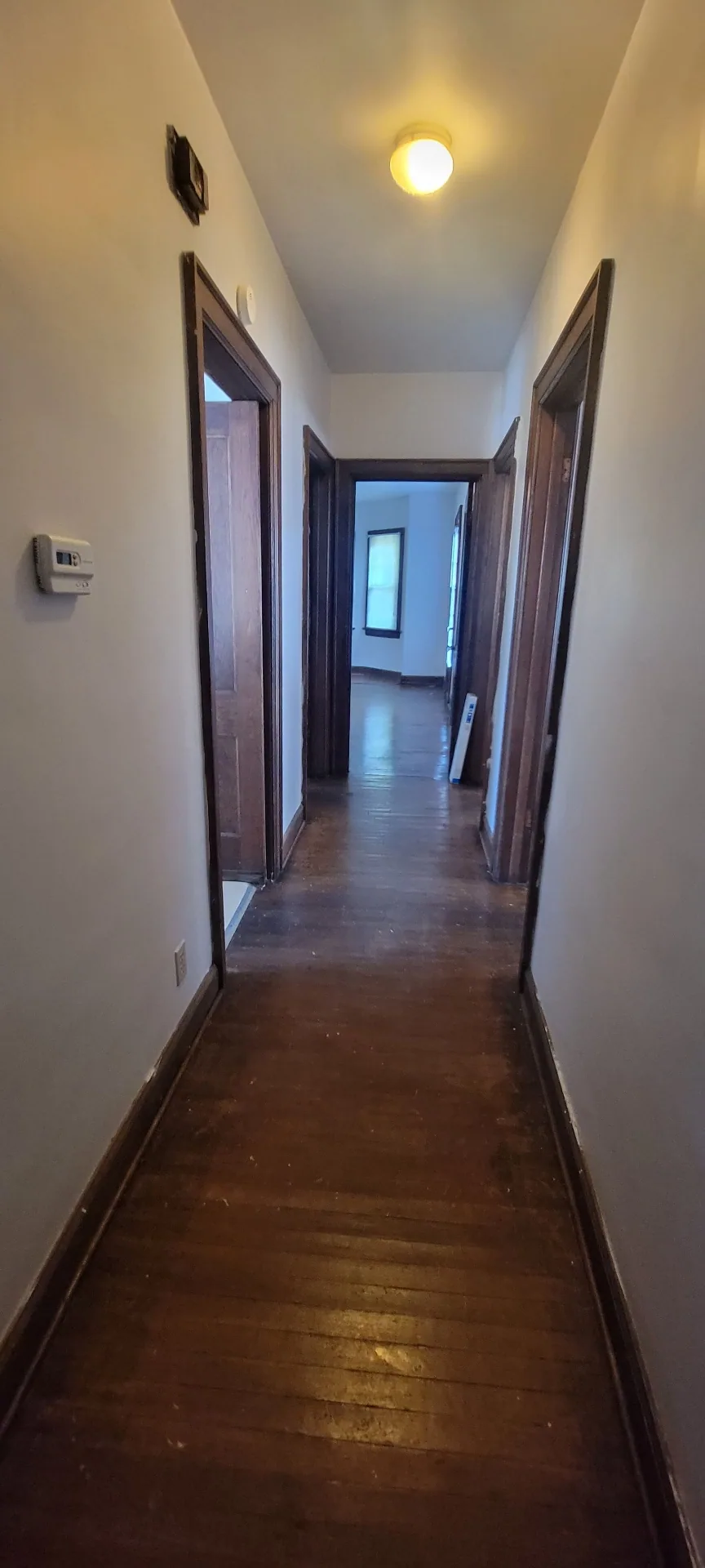 2044 Iuka Ave. C long interior hallway with original woodwork leading toward the living room