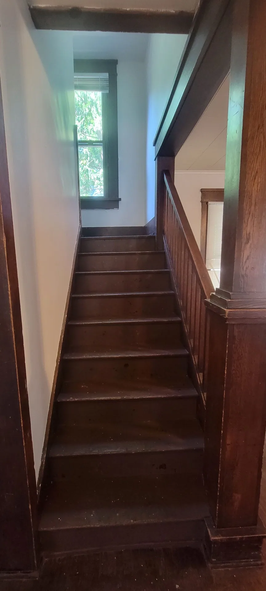 2015 Summit St. wood staircase leading upstairs with tall landing window
