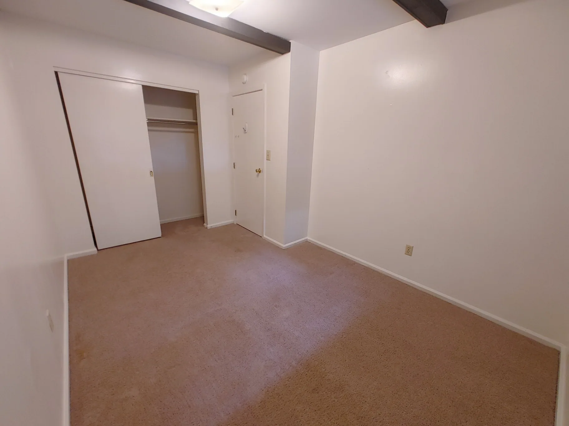2018 Iuka Ave. bedroom with sliding closet, exposed beam, and carpeted floor