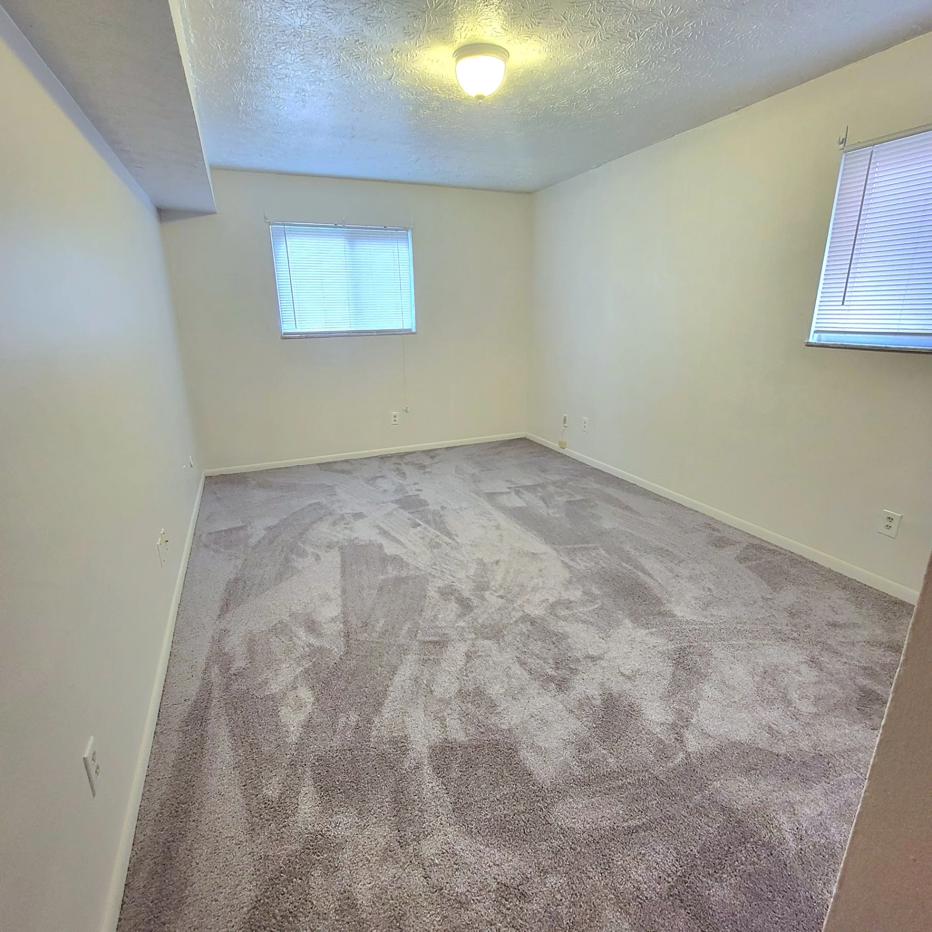 2150 N 4th St. Unit D carpeted bedroom with two windows and ceiling light