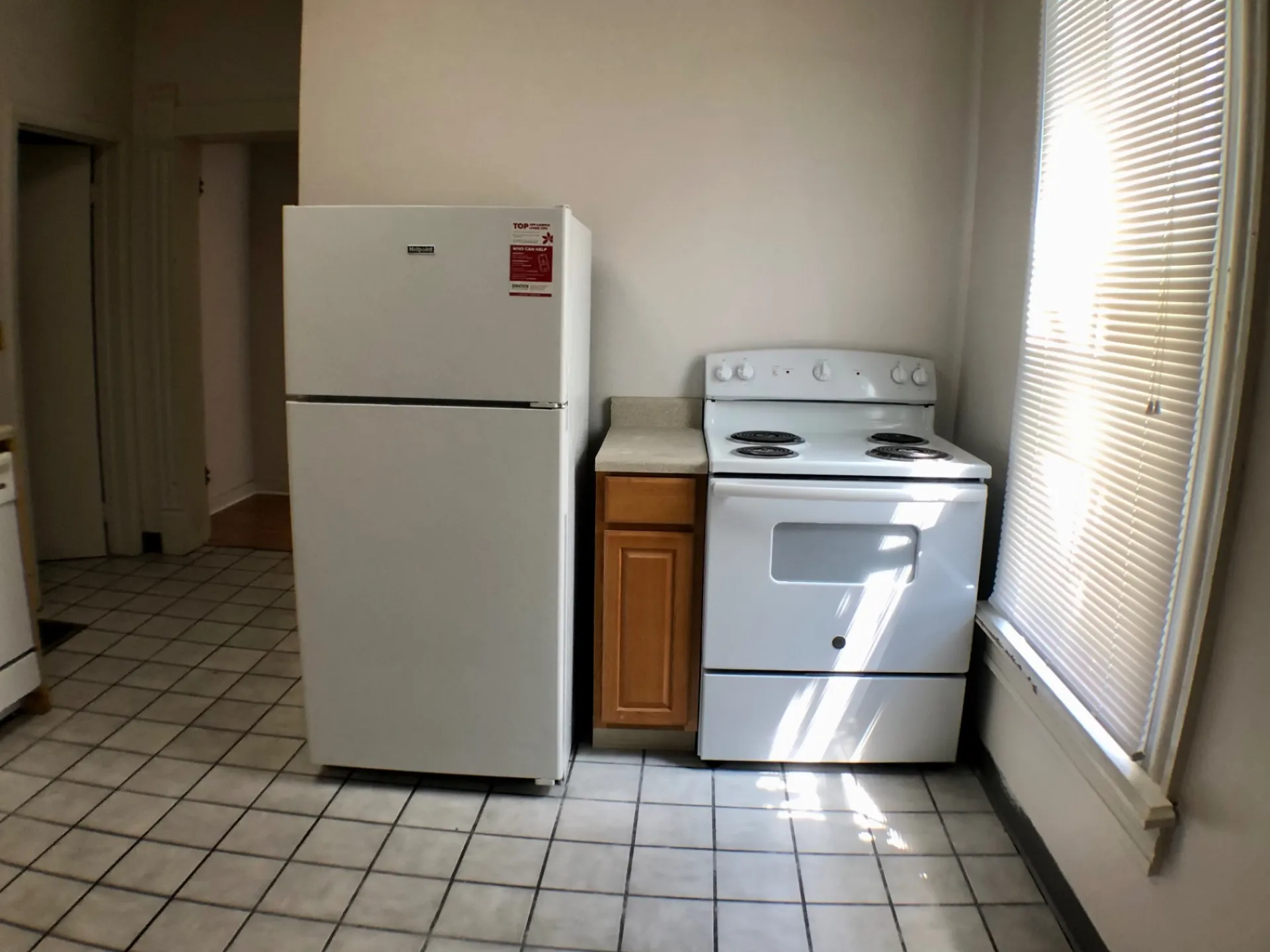 Unit A kitchen with fridge, electric range and hallway to living area