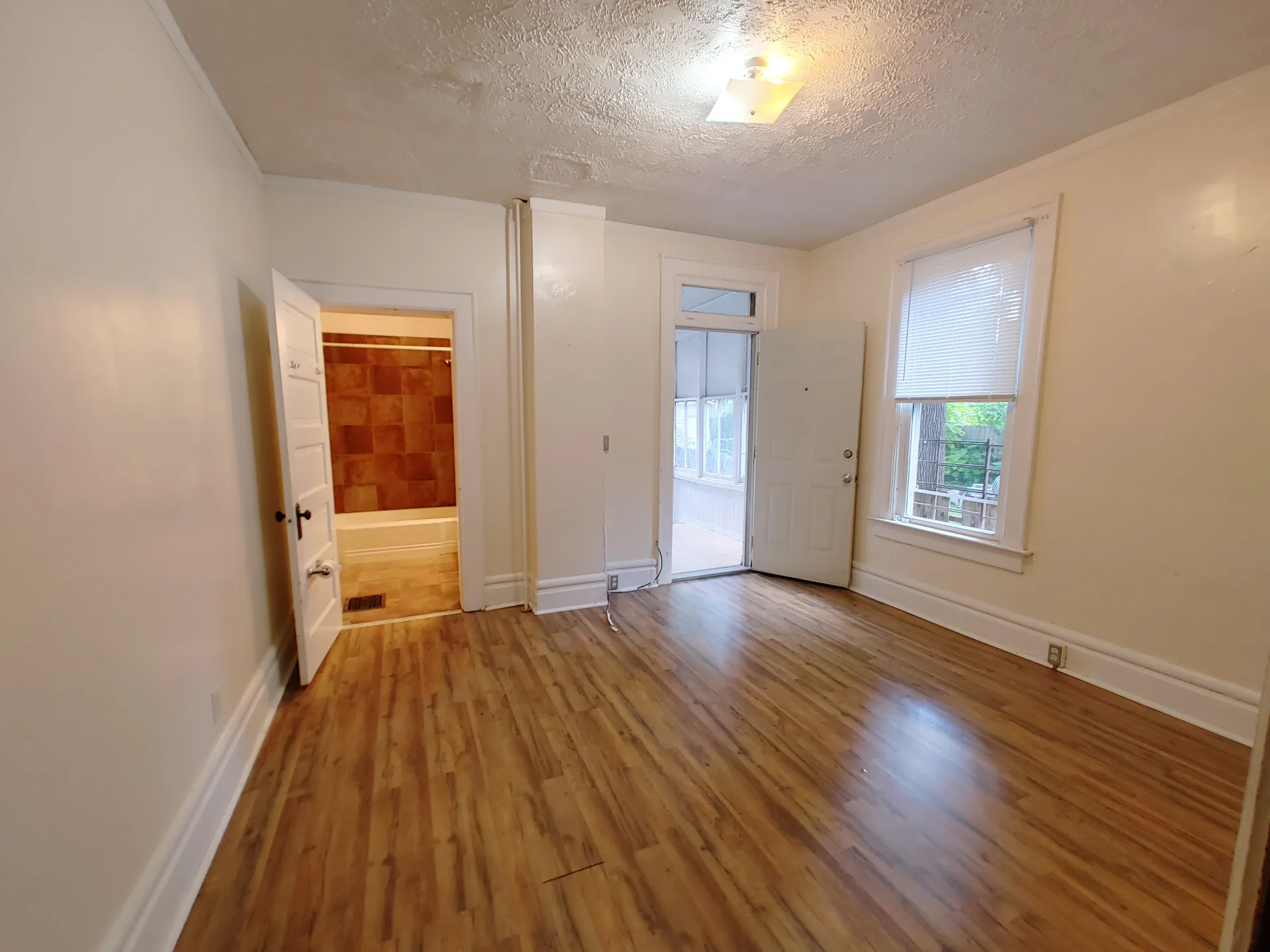 374 A E 14th Ave. back bedroom with plank floors, en-suite bathroom access, and door to rear sunroom
