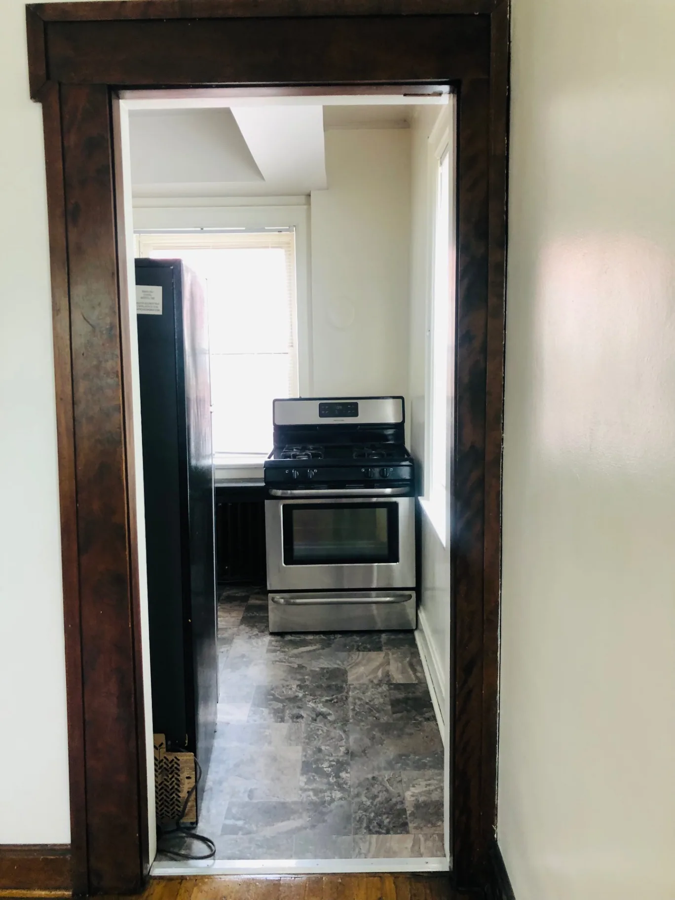 Unit F kitchen view with stainless steel gas range and dark wood trim