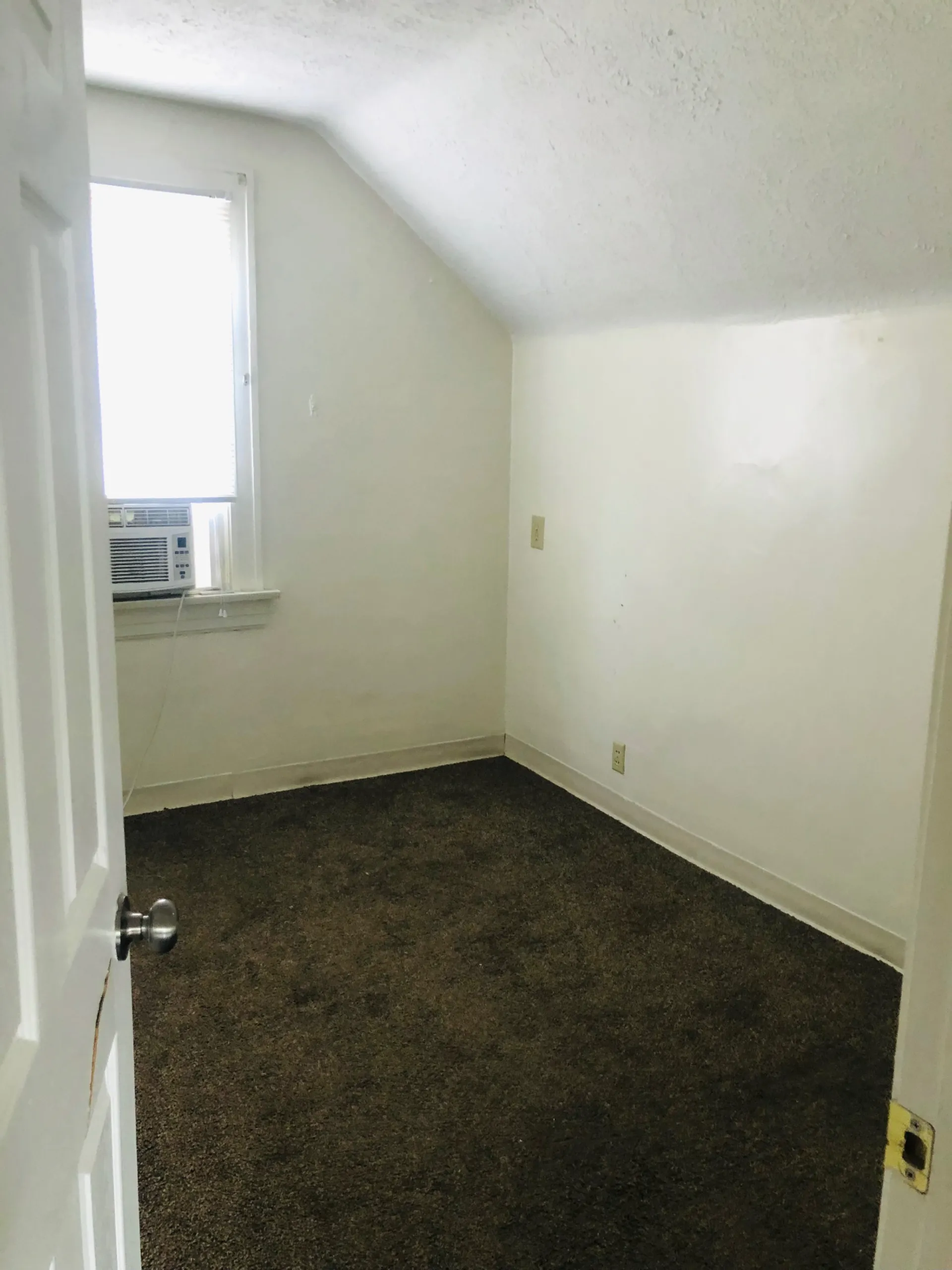 2005 Summit St. upstairs bedroom with sloped ceiling and window air conditioner