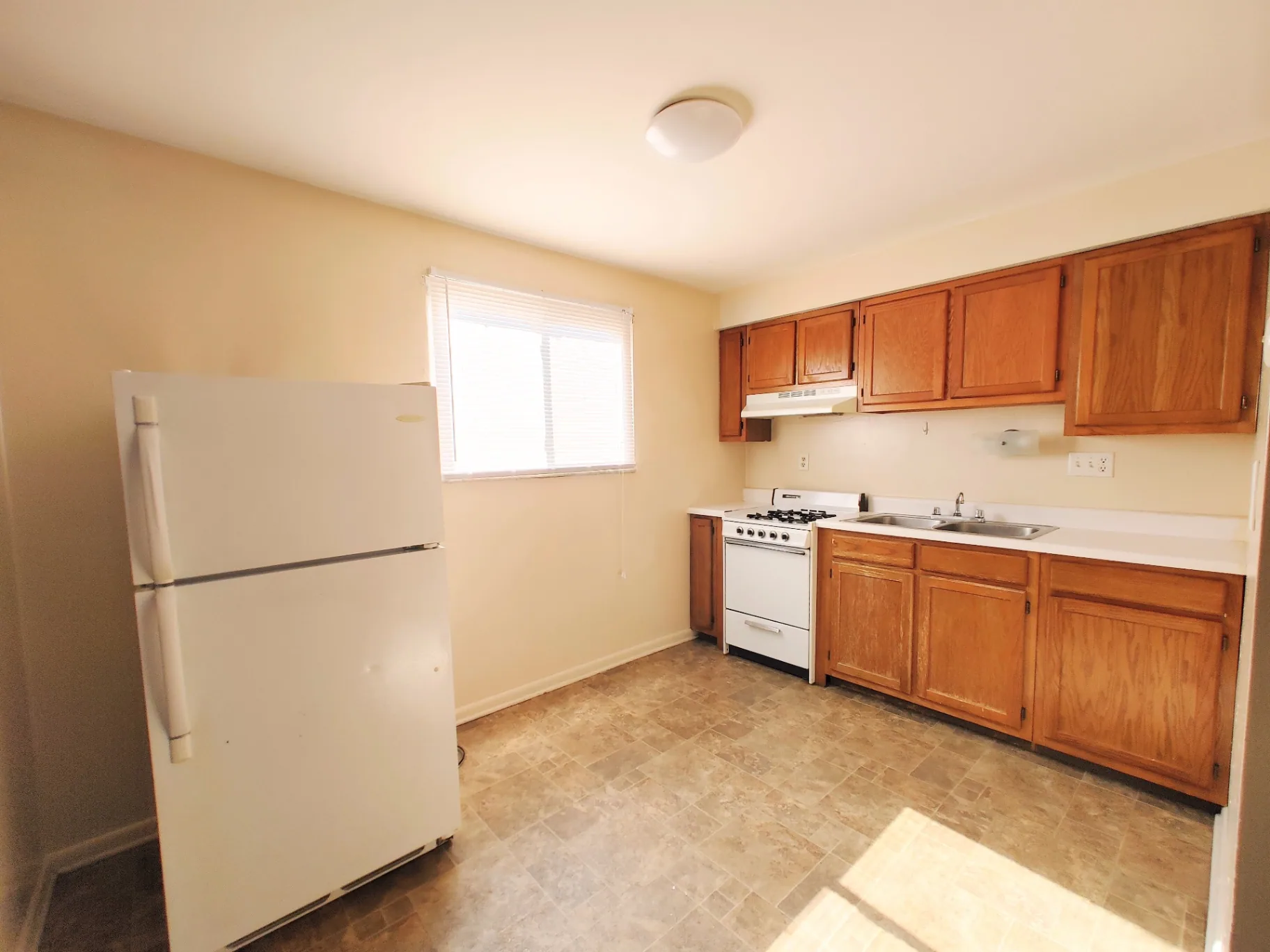 2150 N 4th St. Unit B kitchen with oak cabinets, gas range, and white fridge