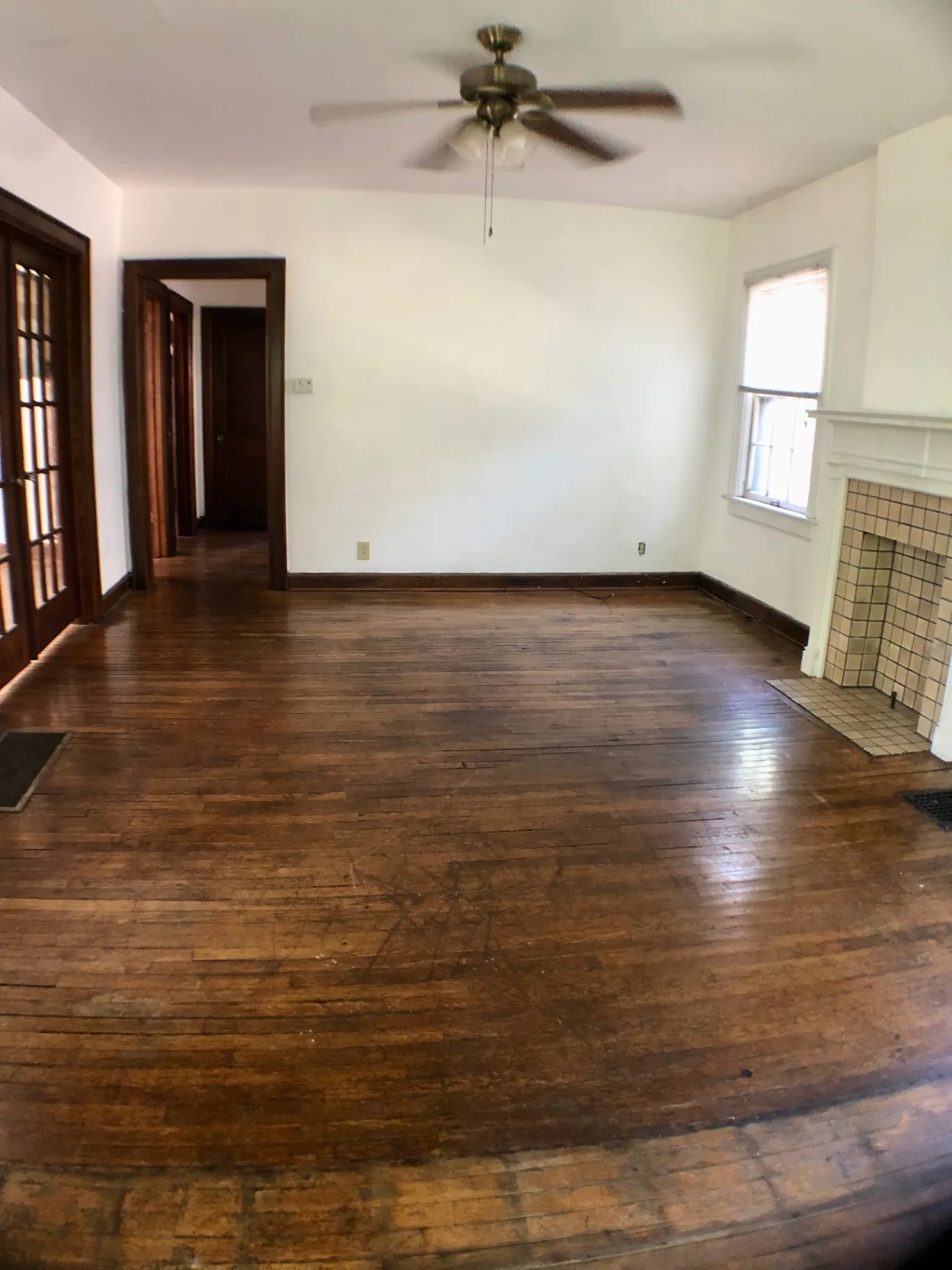 2044 Iuka Ave. A wide living room with hardwood floors, ceiling fan, and tile fireplace