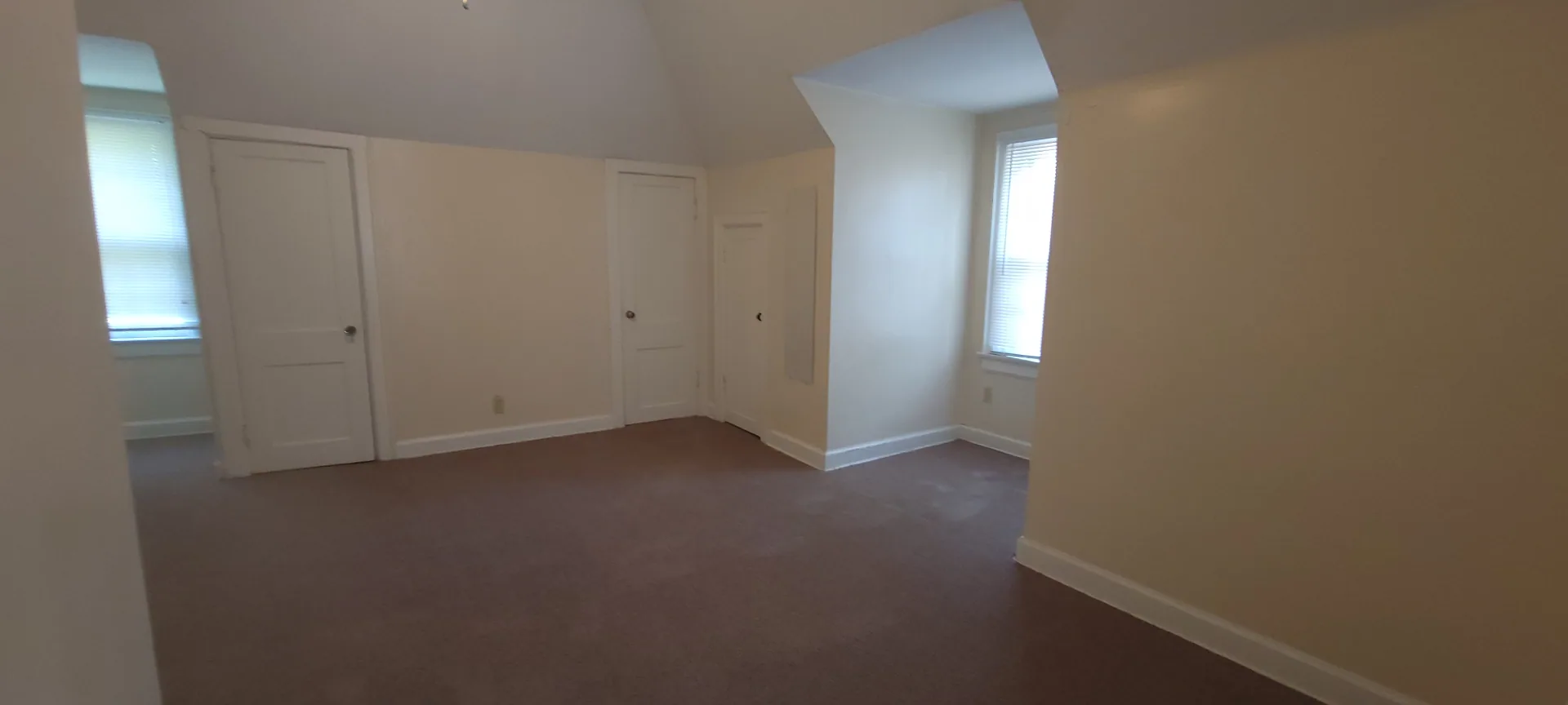 2054 Iuka Ave. C upstairs bedroom with vaulted ceiling and multiple closet doors