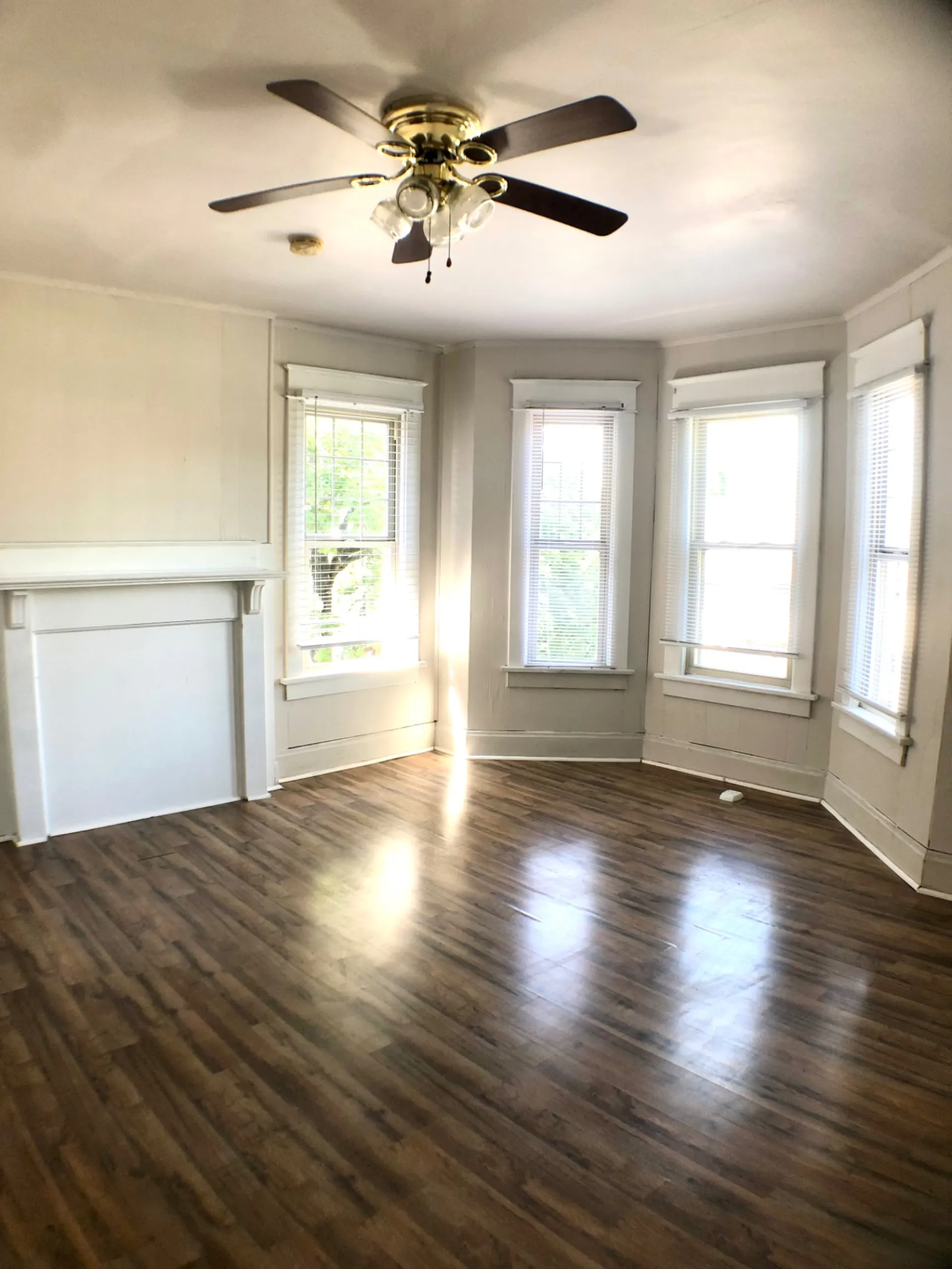 1814 Summit St. living room with white mantel, ceiling fan, and multi-window bay