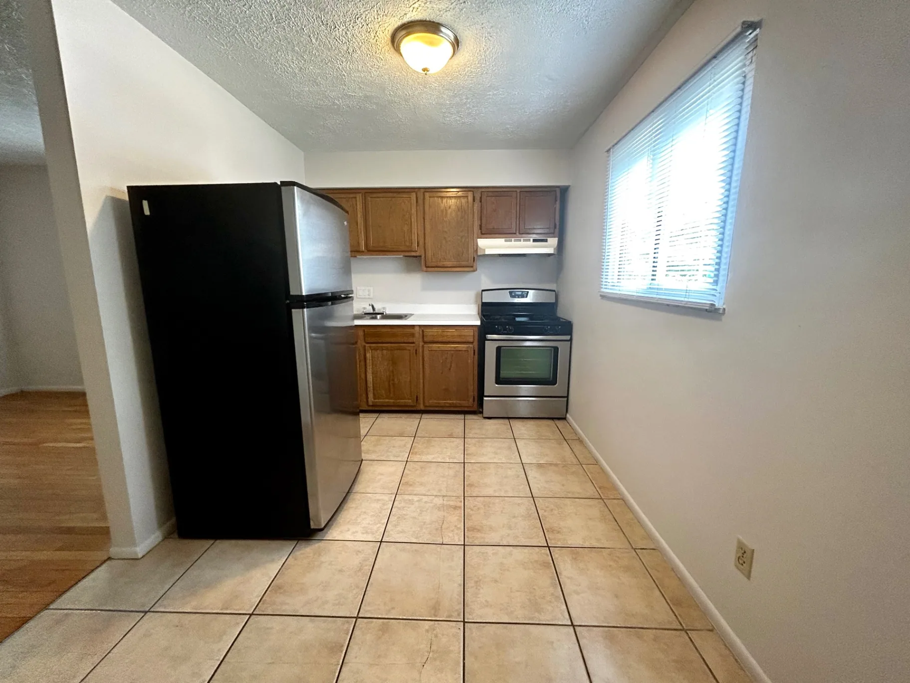 2150 N 4th St. Unit C kitchen with oak cabinets, gas range, stainless fridge, and tile floor