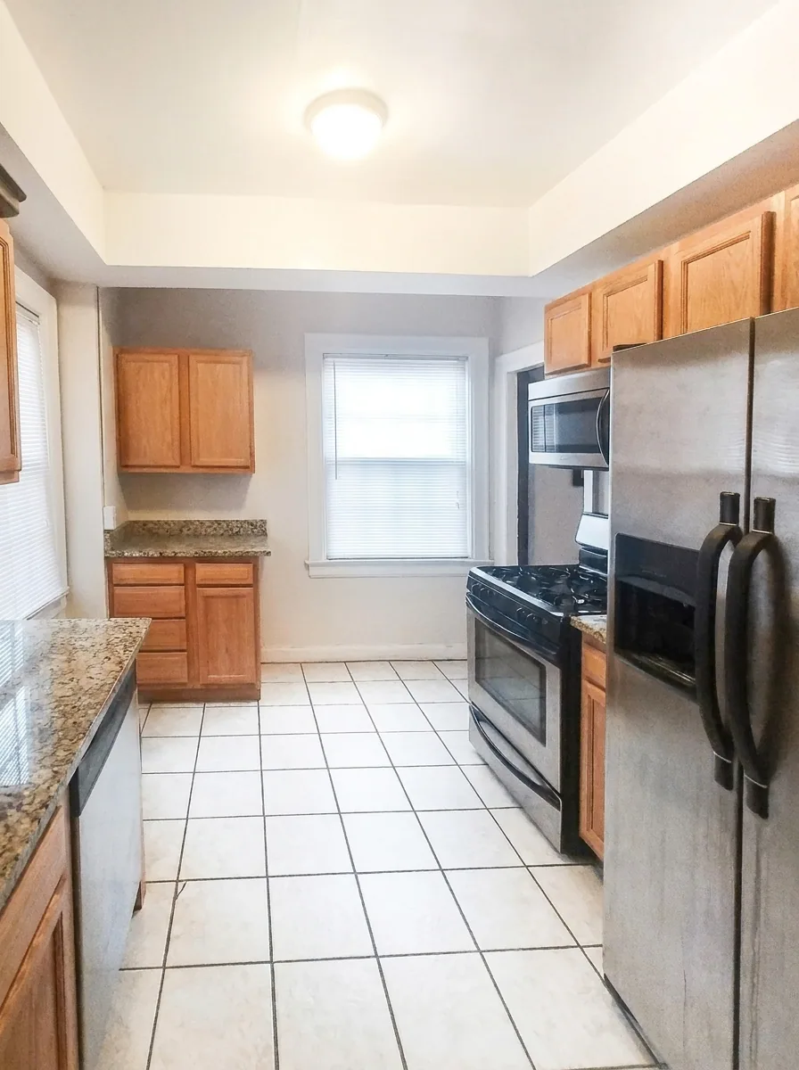 Unit C kitchen with stainless steel appliances and granite countertops
