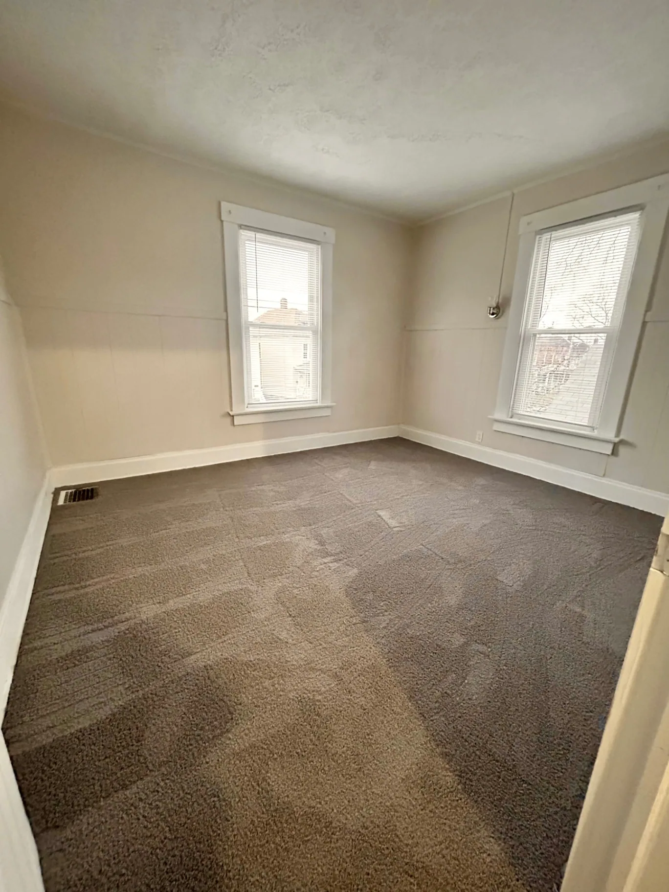 68 E Patterson Ave. carpeted bedroom with two bright windows and painted wainscot trim