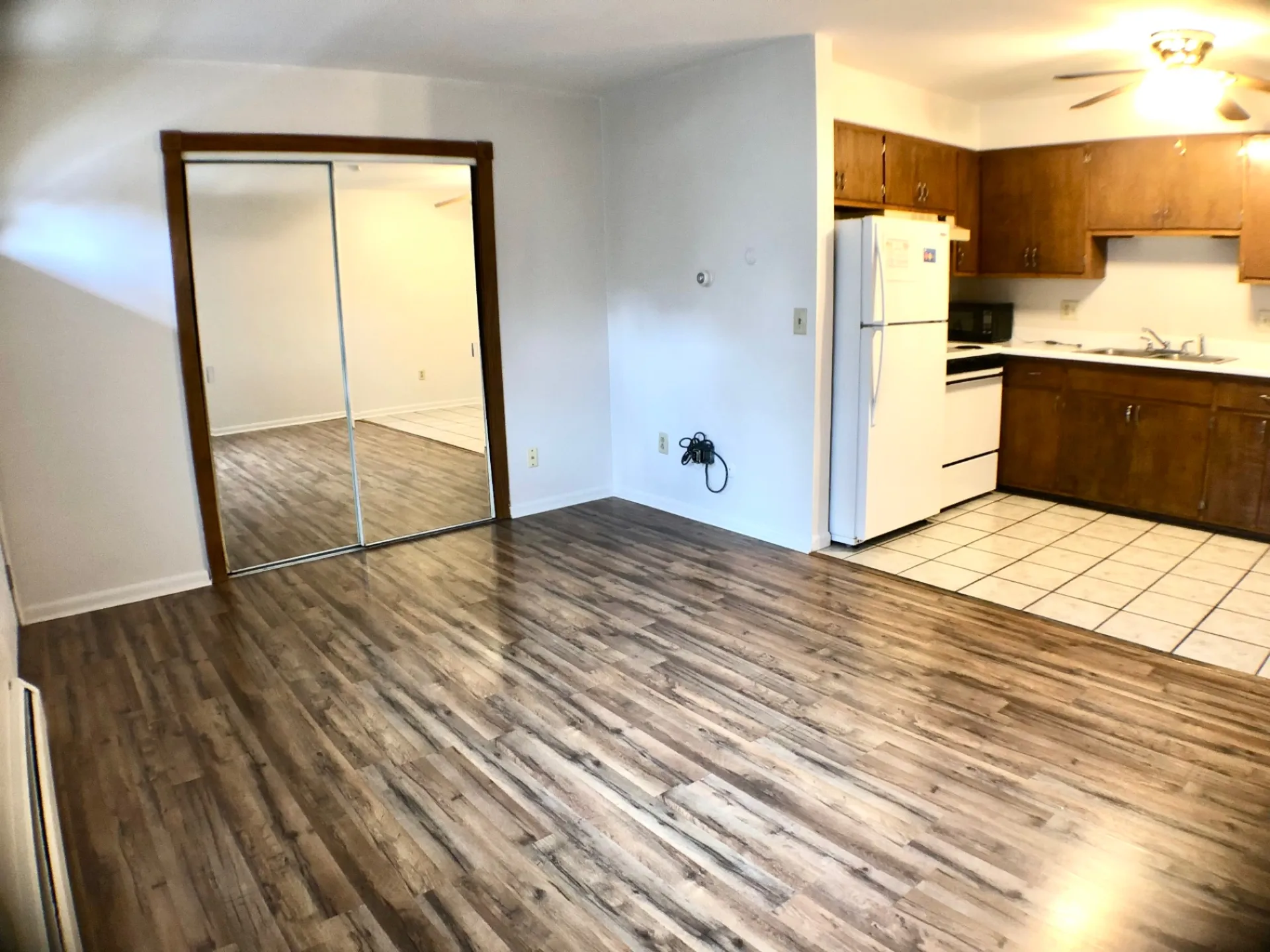1827 N 4th St. Unit 4 open living area with wood-look flooring, mirrored closet doors, and adjacent tile kitchen