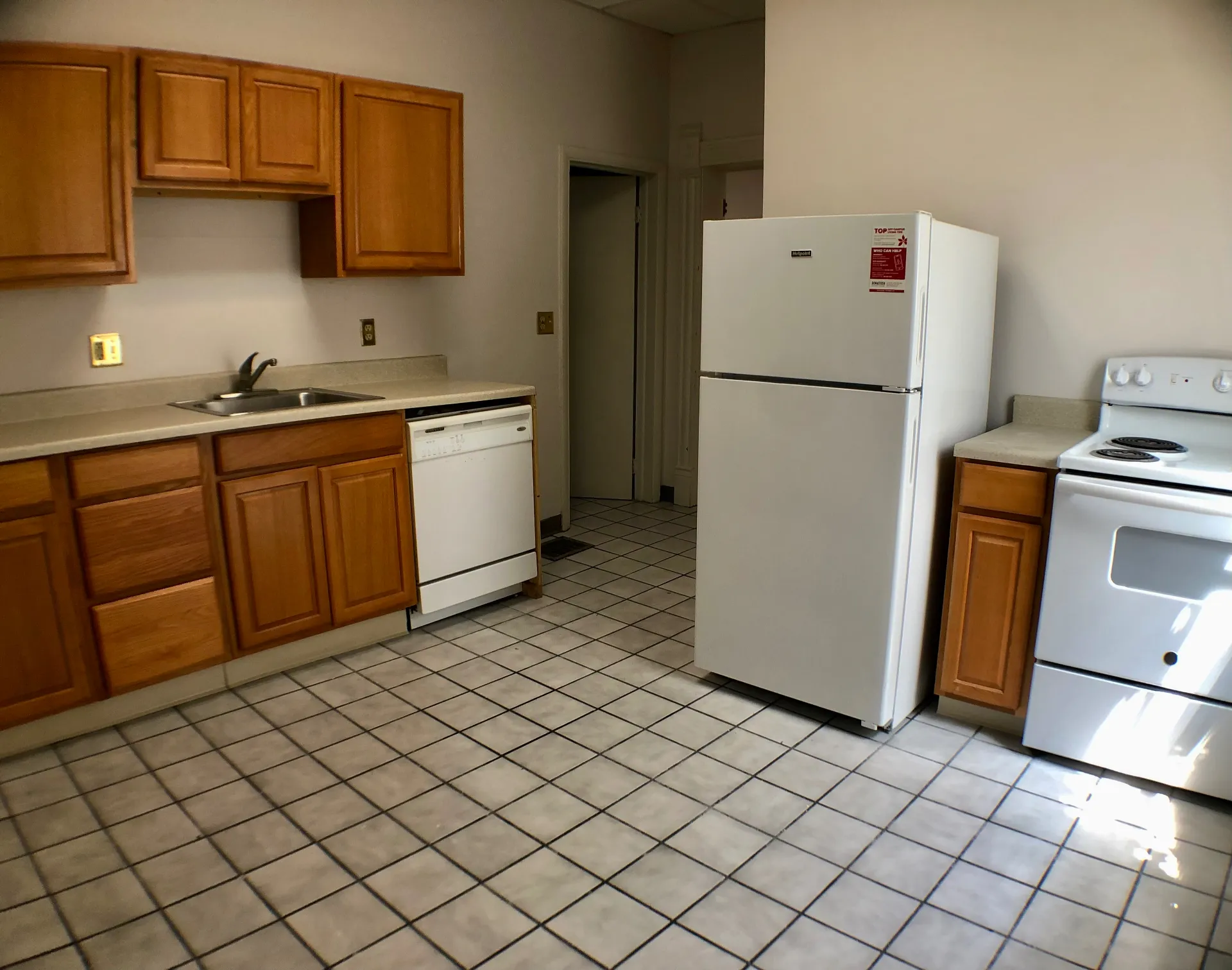 Unit A eat-in kitchen with maple cabinets, dishwasher, full-size fridge and electric range