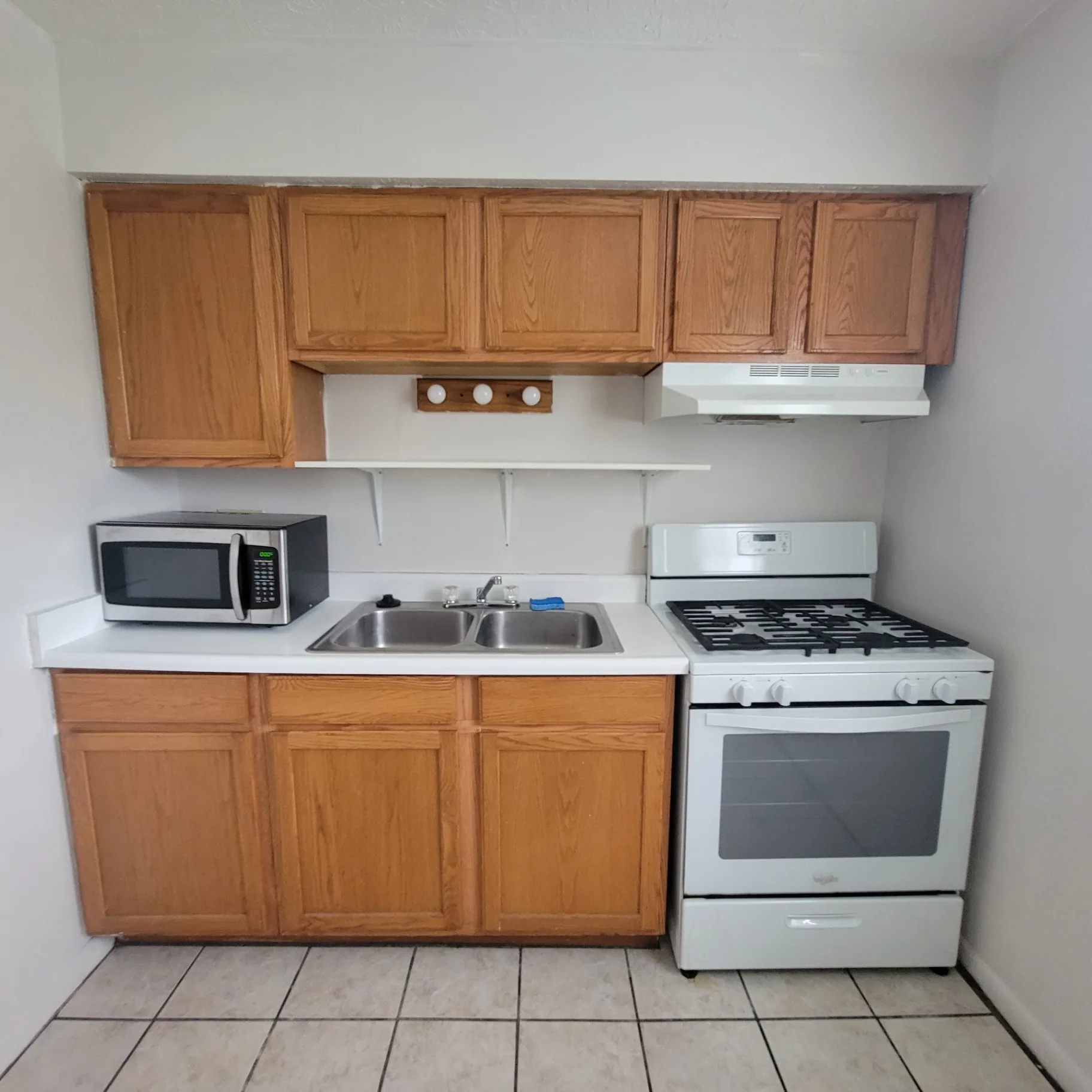 2150 N 4th St. Unit F kitchen with oak cabinets, gas range, and double-basin sink