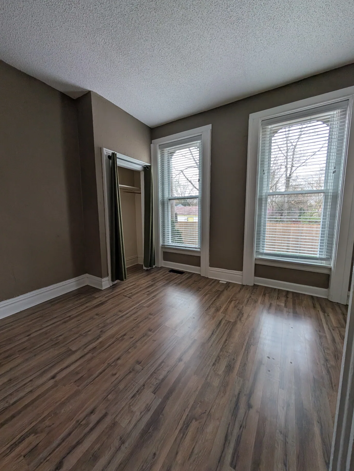 3338 Chestnut Downstairs bedroom with laminate floors and tall windows overlooking the yard