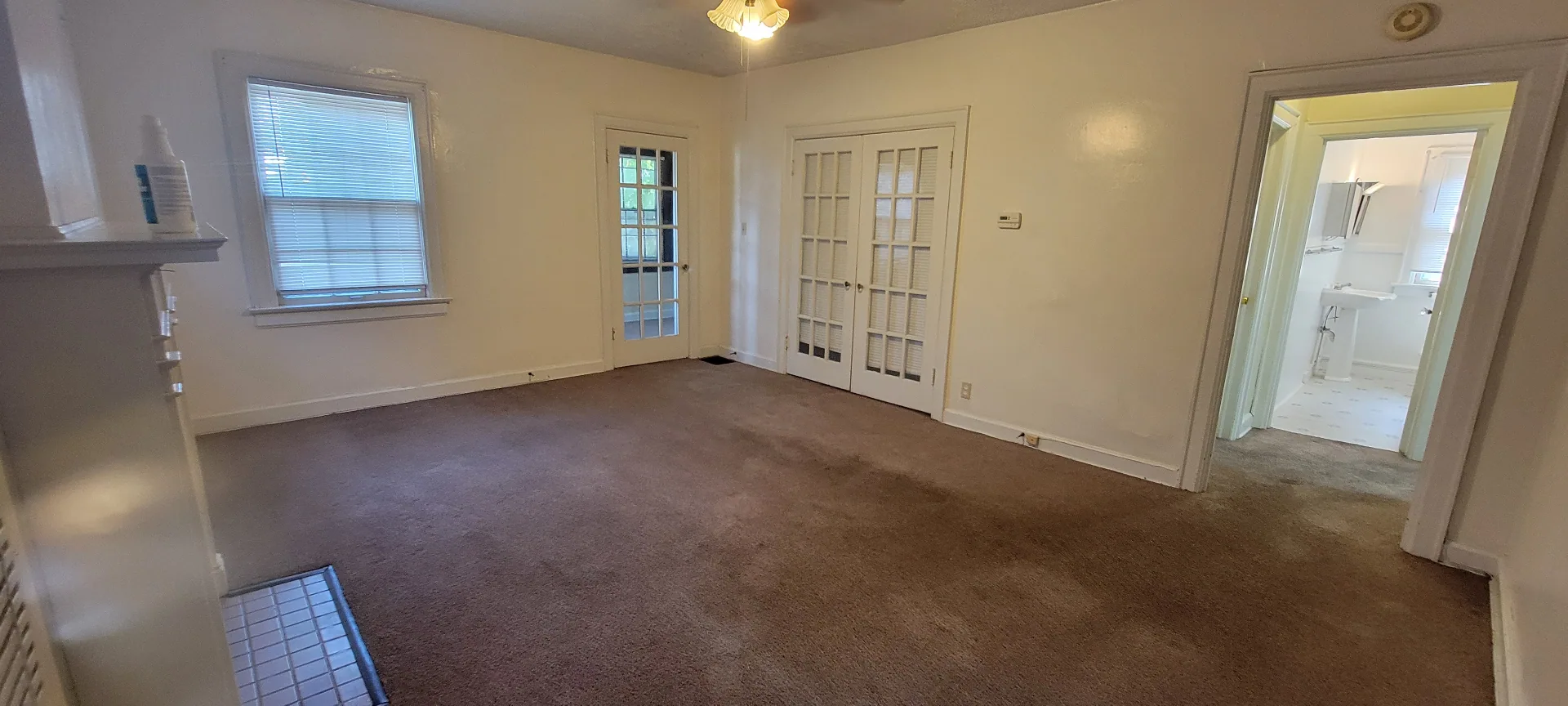 2044 Iuka Ave. D wide living room with French-door entries, ceiling fan, and bathroom access