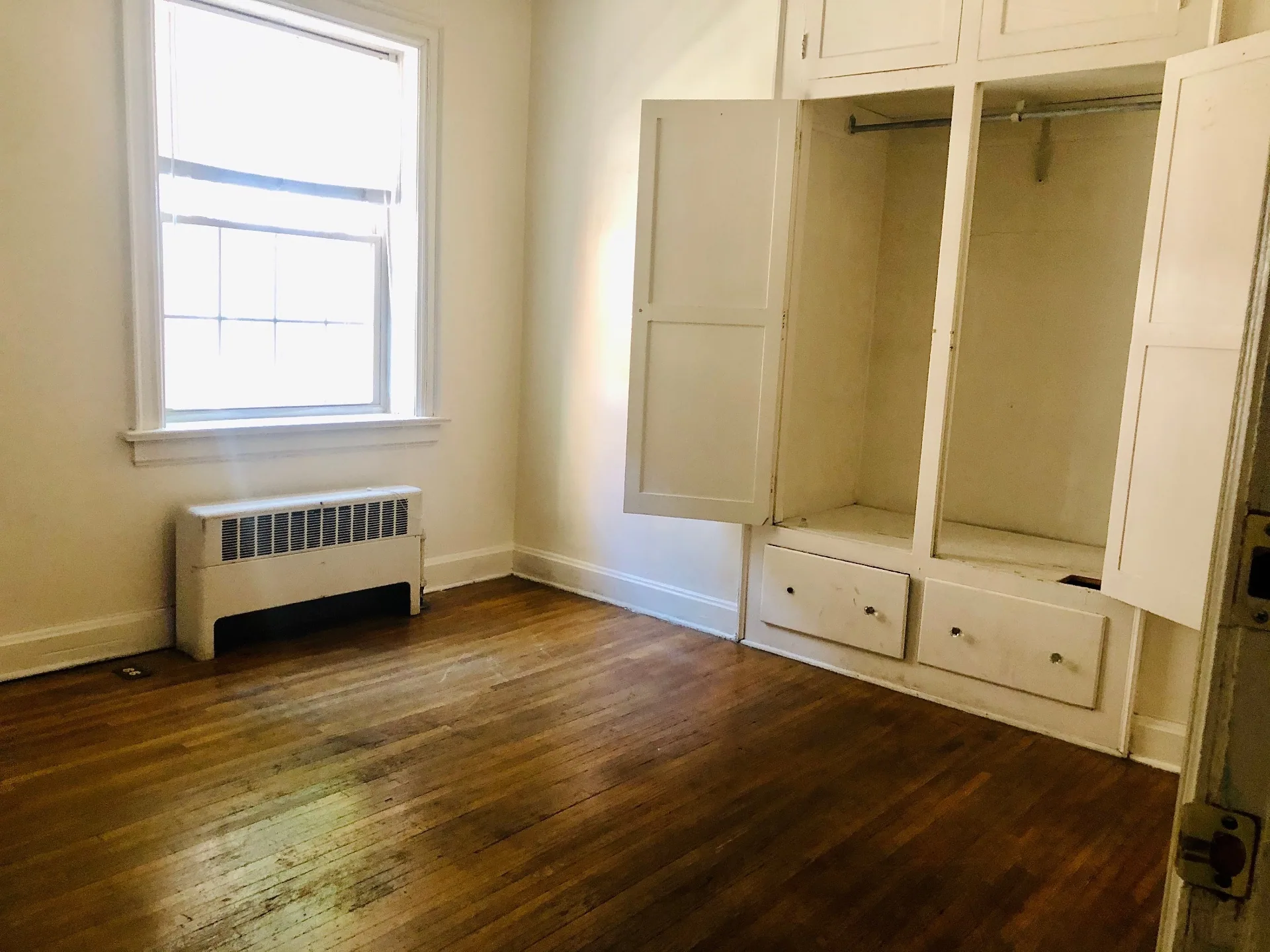 Unit G bedroom with hardwood floors and built-in closet