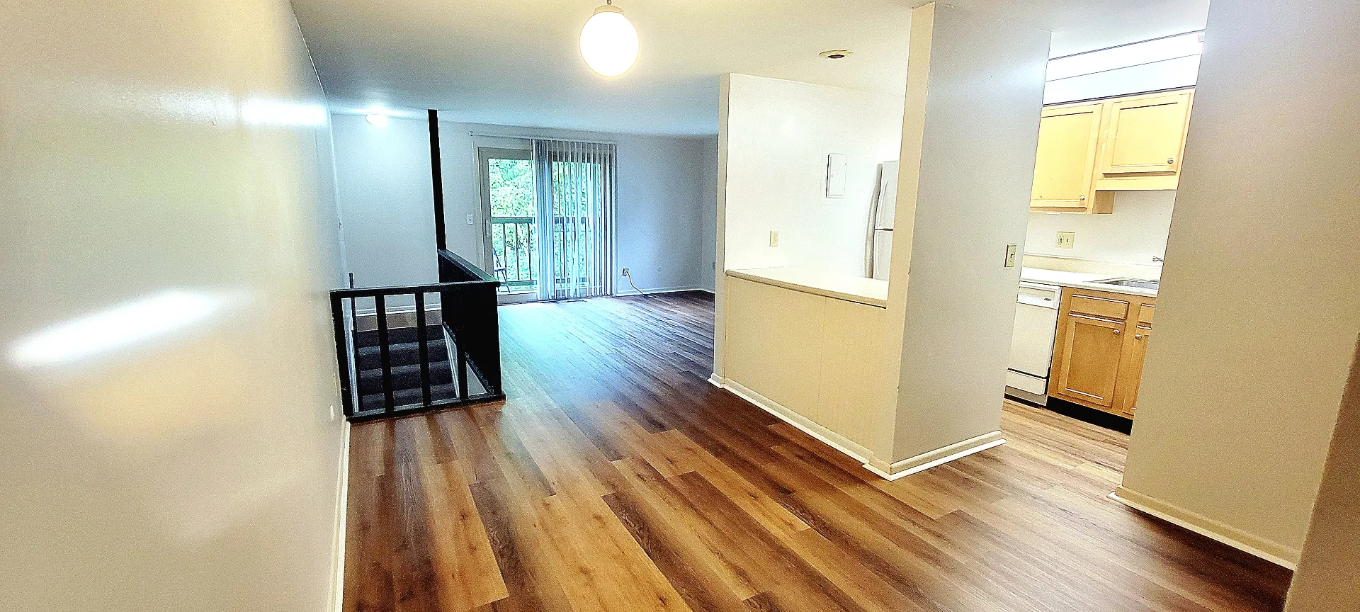 2024 Summit St. bright open living area with wood-look plank floors, staircase, and pass-through kitchen