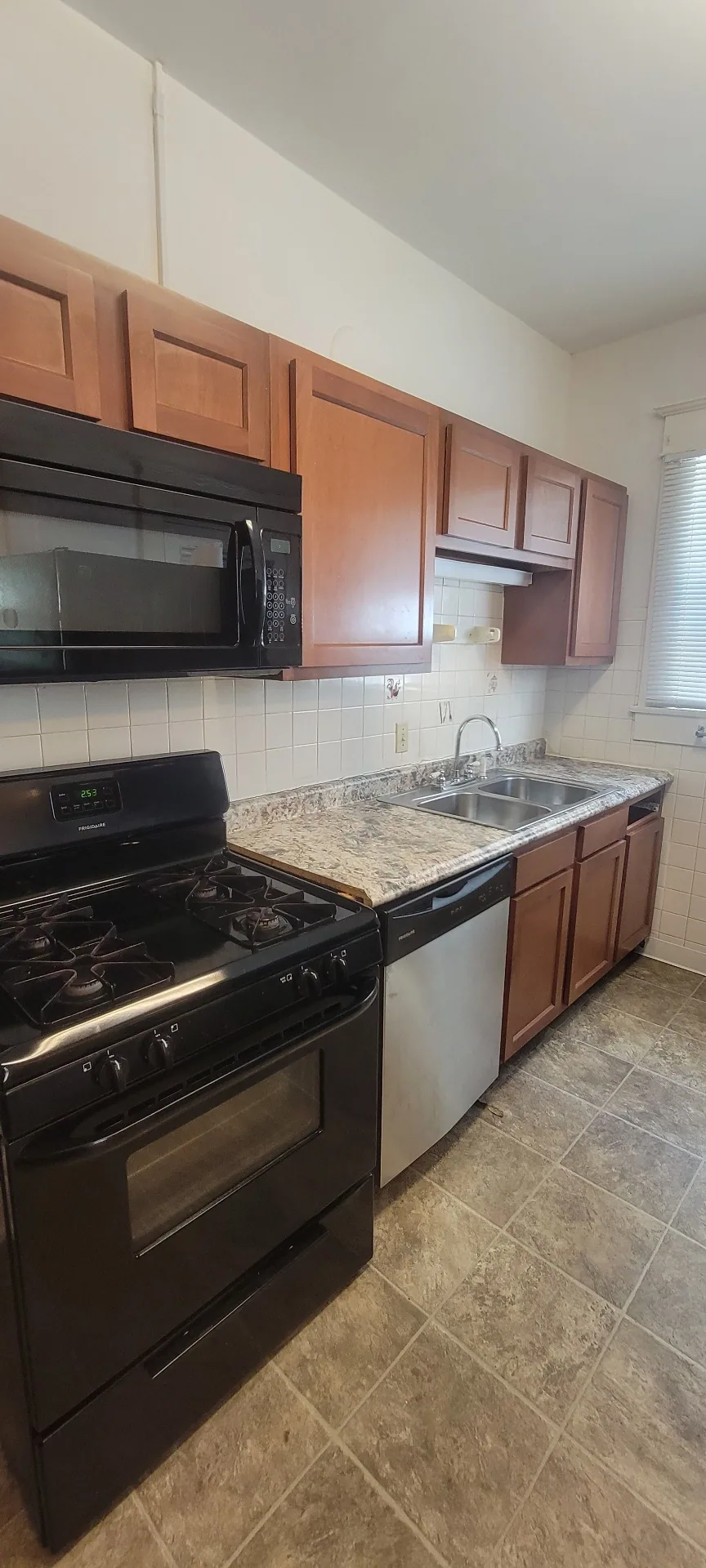 2015 Summit St. kitchen with gas range, stainless dishwasher, and tile backsplash