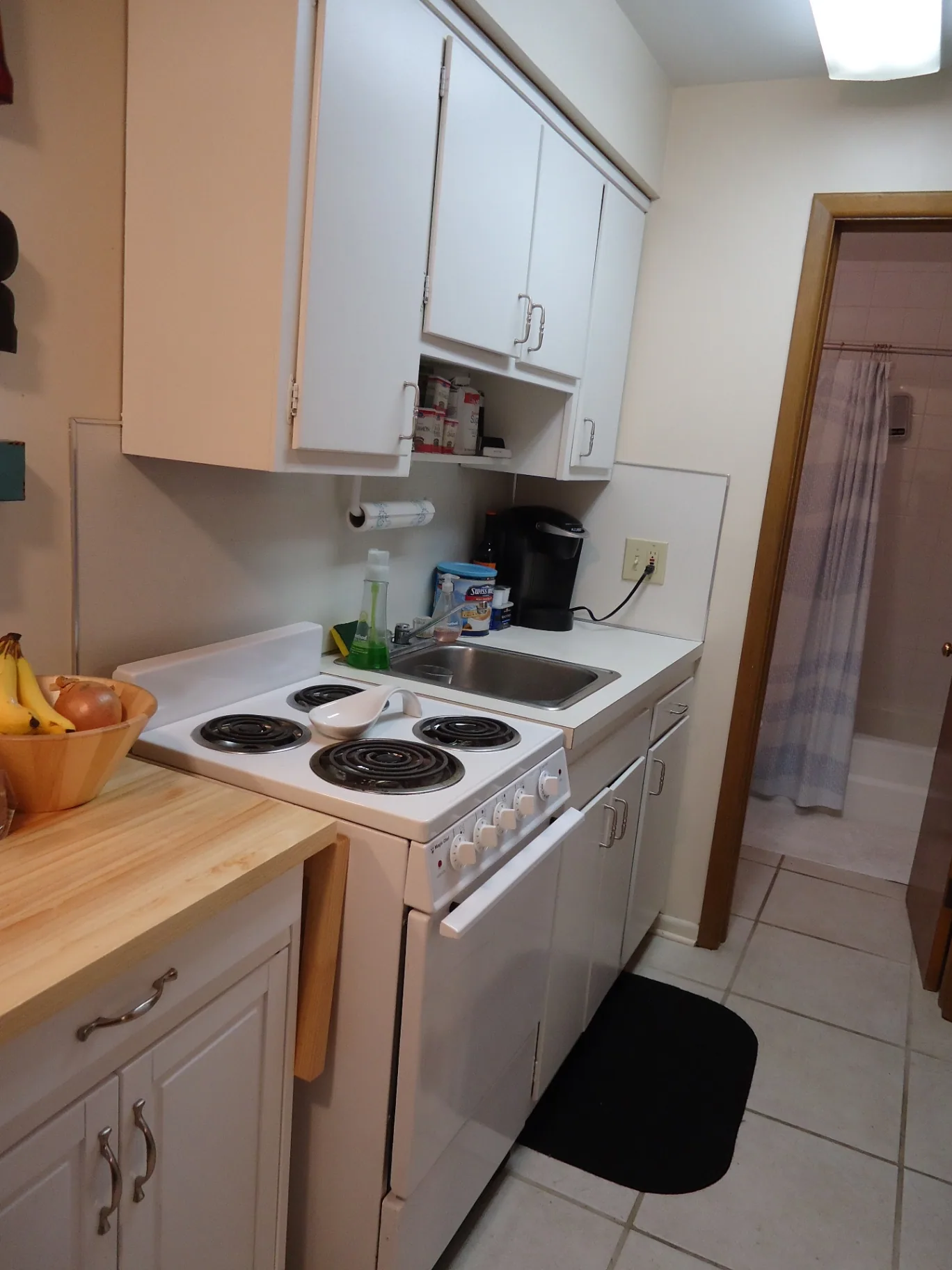 2040 Iuka Ave. 4B kitchen with white cabinets, electric range, and tile floor