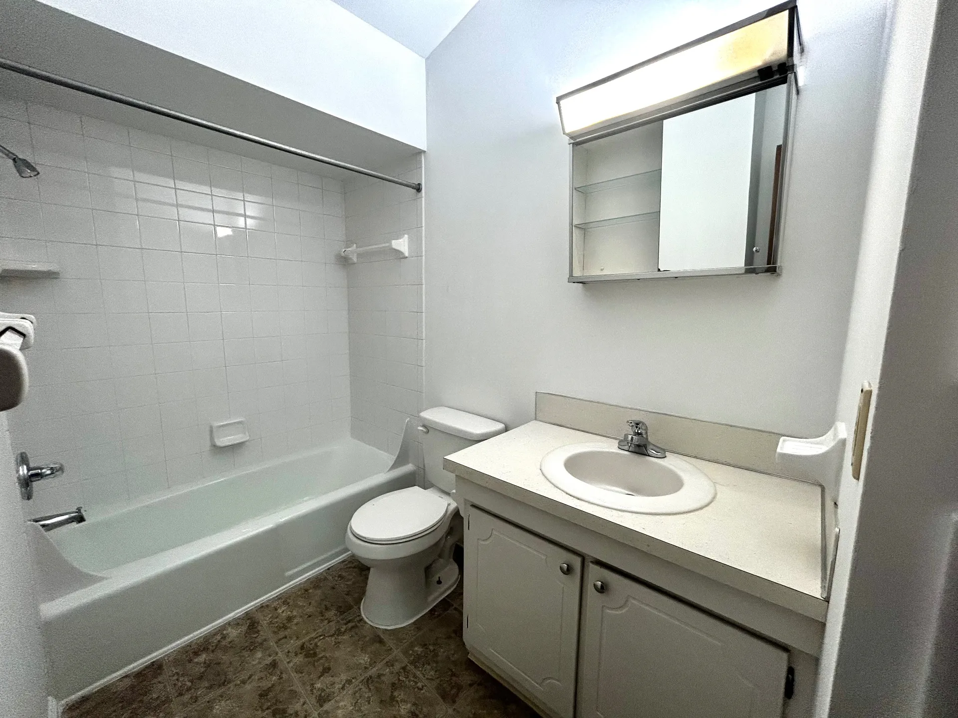 2011 Summit St. Unit E bathroom with tub shower, vanity, and tile flooring