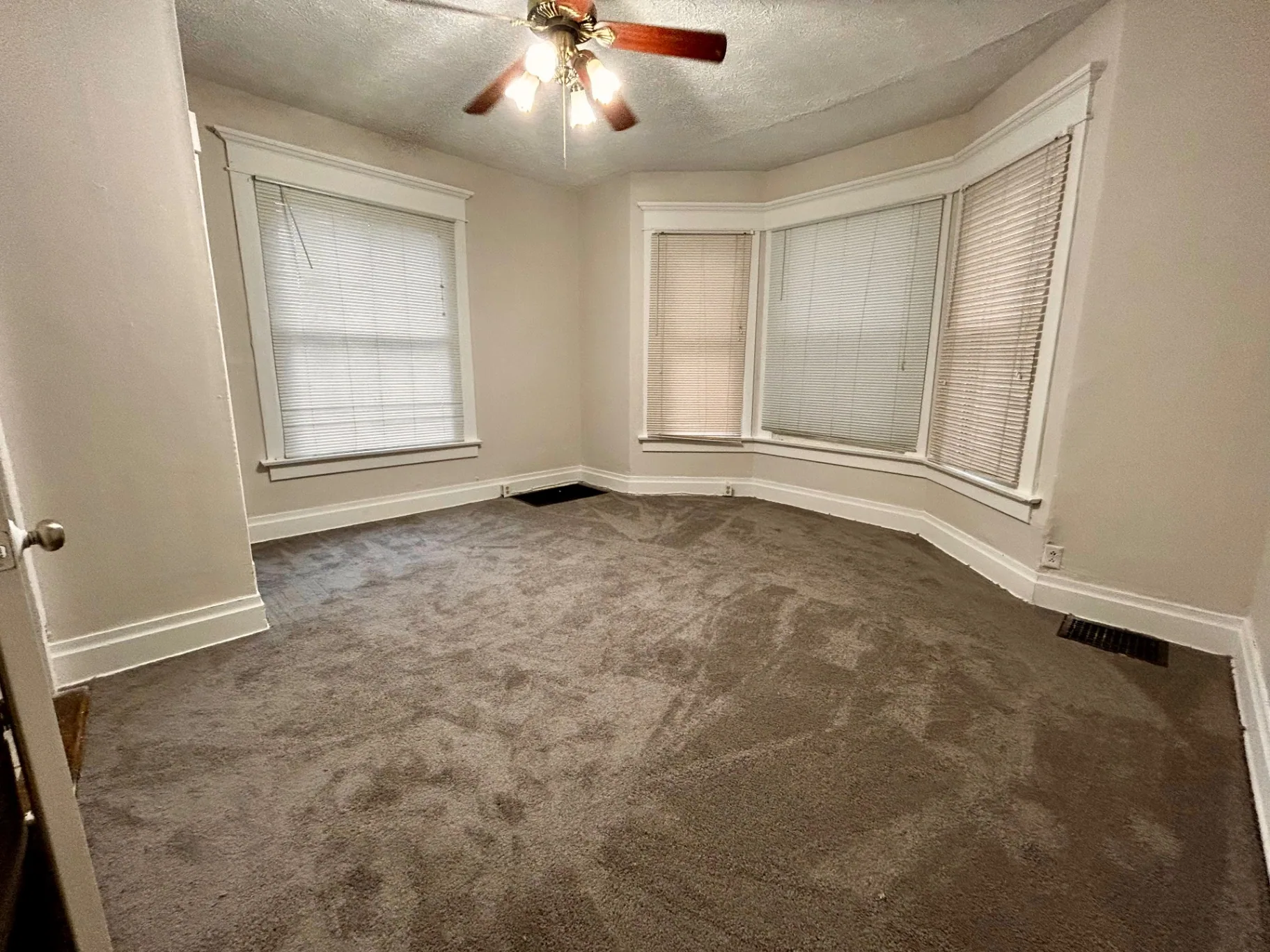68 E Patterson Ave. carpeted room with large bay window, ceiling fan, and side window