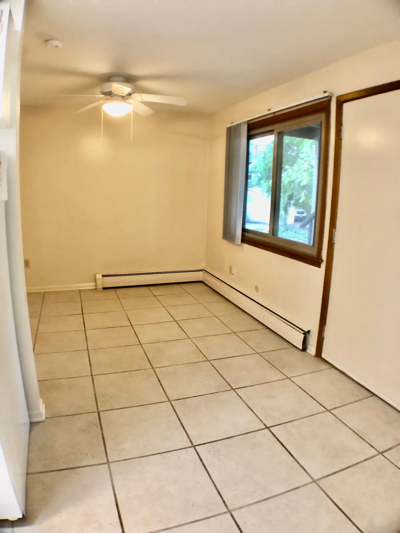 2040 Iuka Ave. 5A living room with ceiling fan, tile flooring, and large window overlooking the courtyard