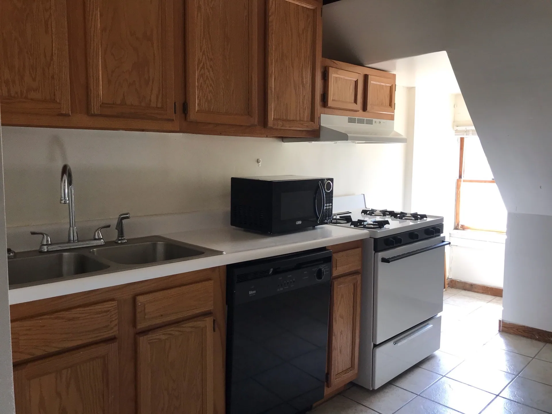 89 E Woodruff Ave. Unit C kitchen with double stainless sink, dishwasher, and dedicated stove nook