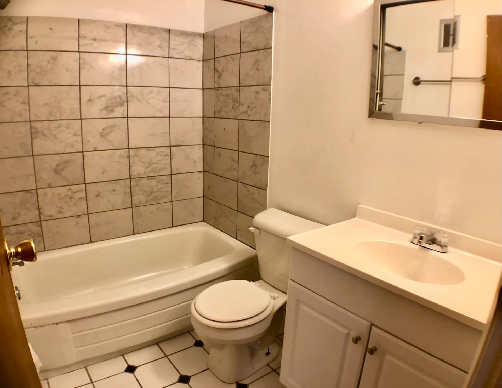 1827 N 4th St. Unit 1 bathroom with pedestal-style vanity, tub, and tiled walls