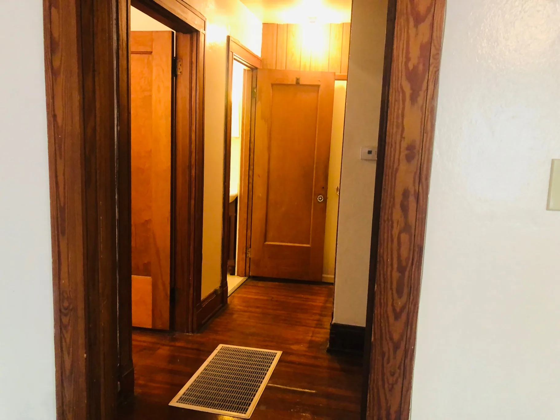 2026 Iuka Ave C hallway with warm wood trim connecting bedrooms and bath
