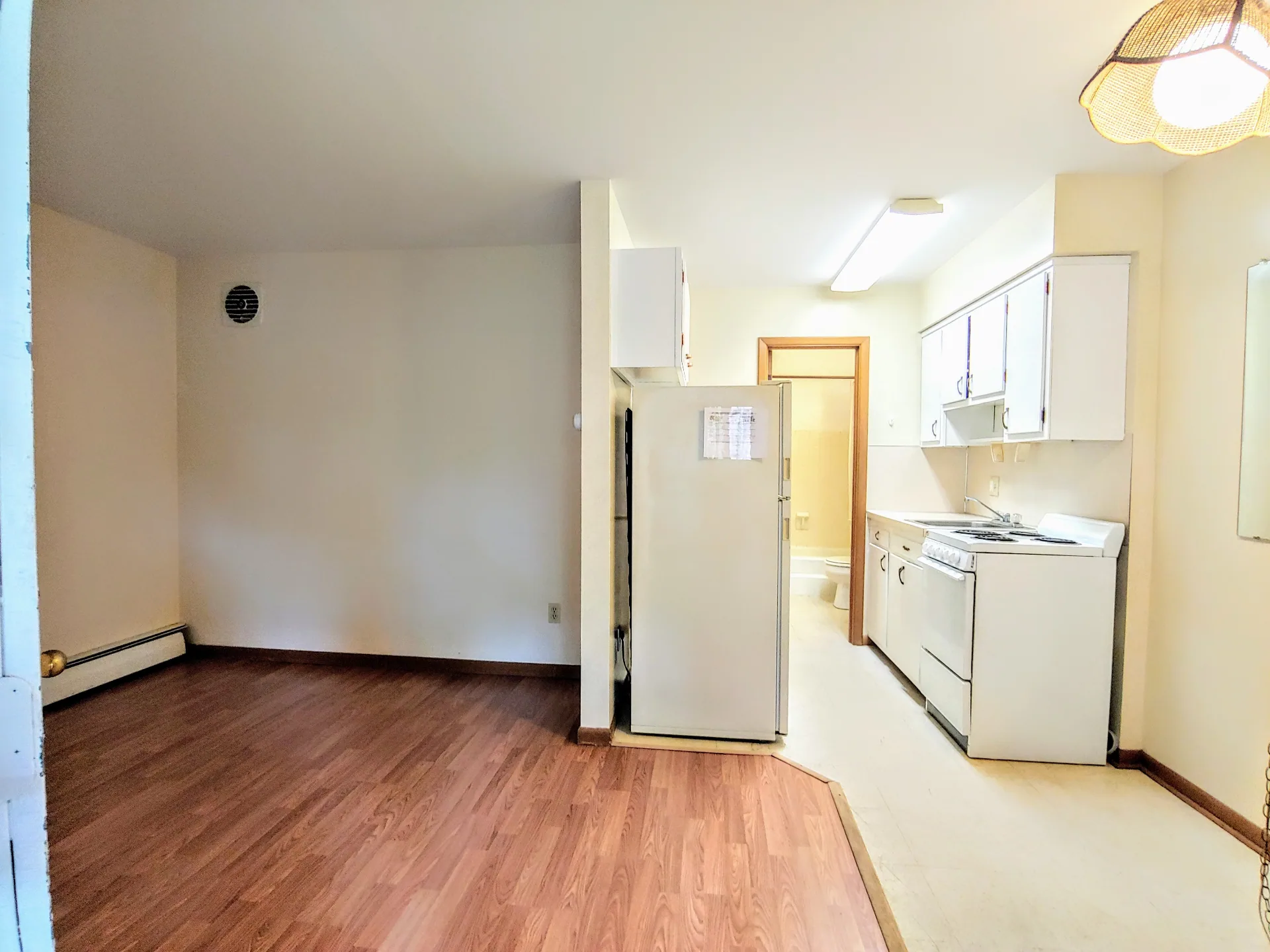 2040 Iuka Ave. 4A open living area with wood laminate floors and view into white kitchen