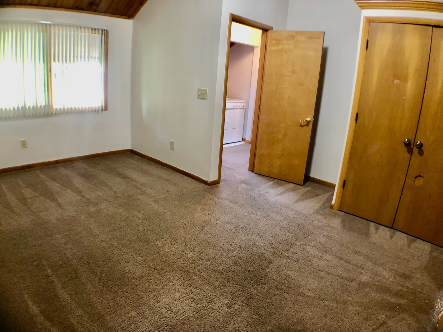 2040 Iuka Ave House bedroom with vaulted wood ceiling and door to laundry area