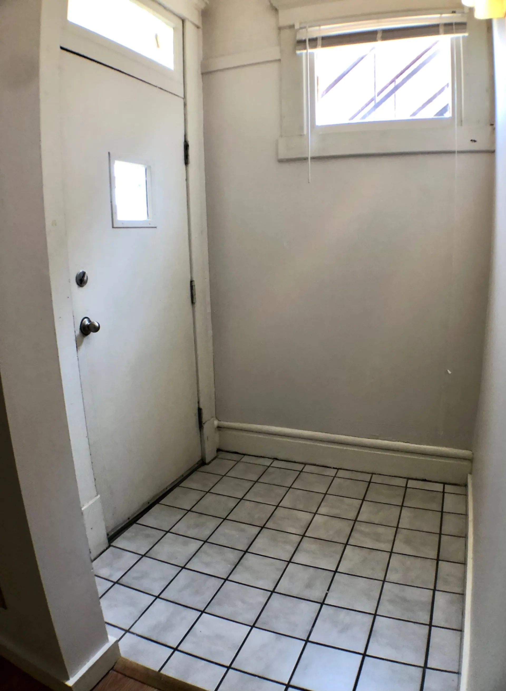 Unit A mudroom entry with tile floor and transom window