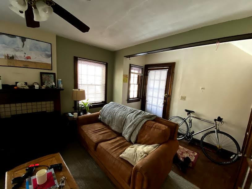 2054 Iuka Ave. B living room with tile fireplace, wood mantel, ceiling fan, and natural light
