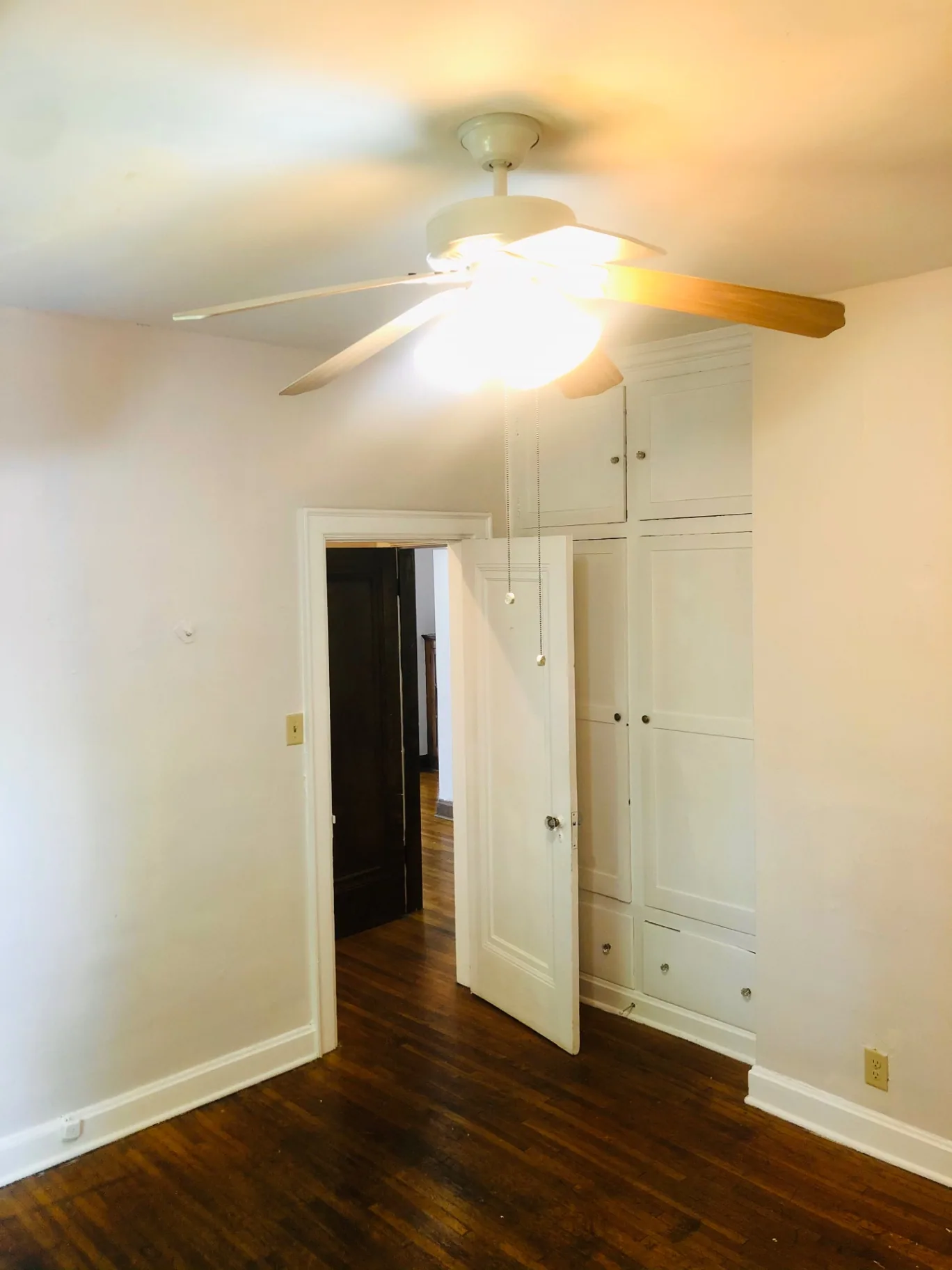 Unit L second bedroom with built-in cabinets and ceiling fan