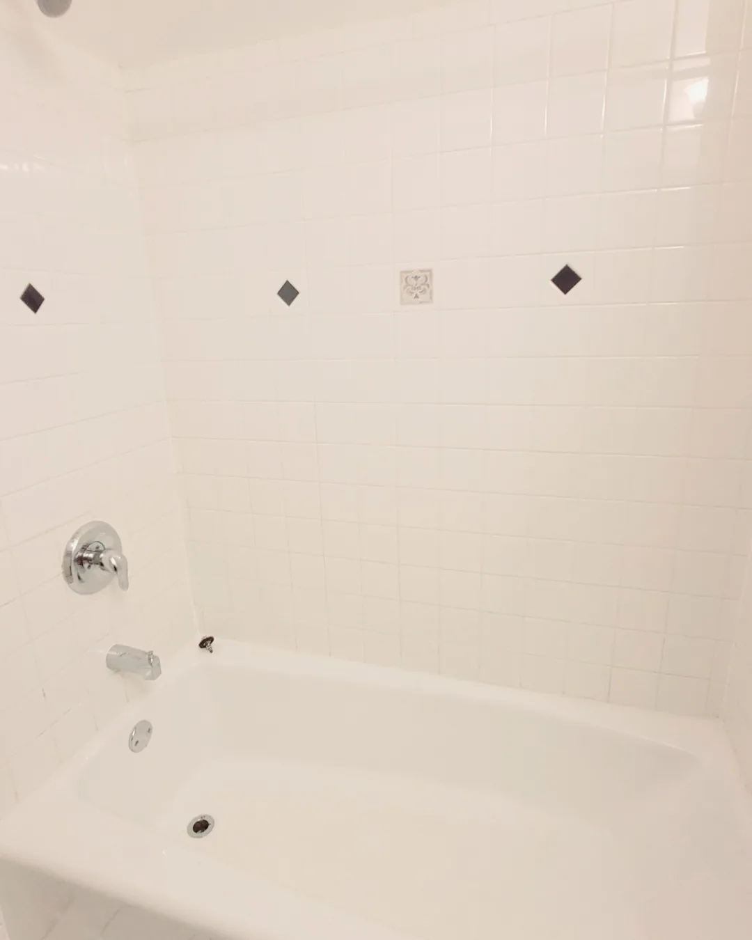 Unit A bathroom shower and tub with white tile surround