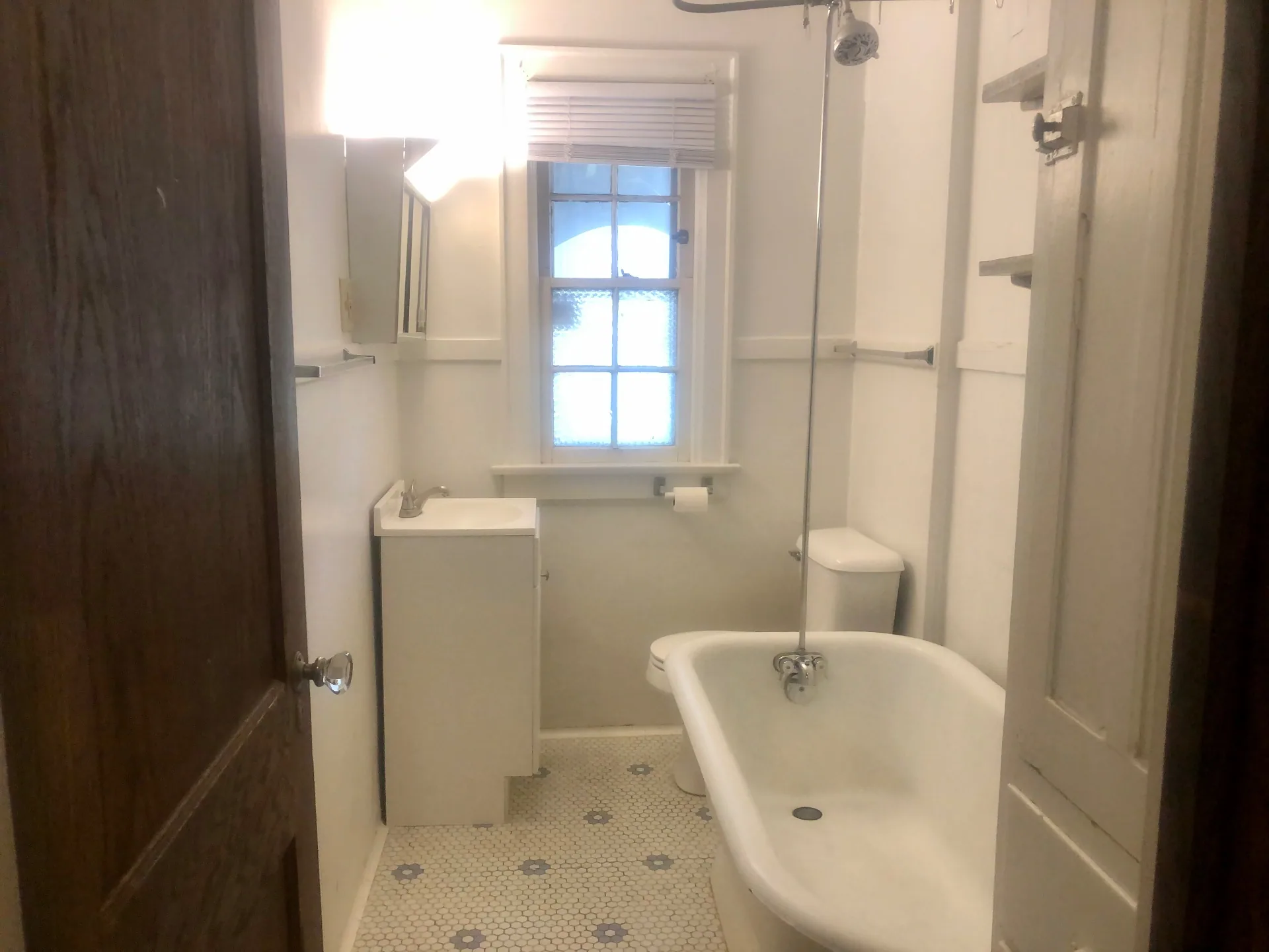 2048 Iuka Ave. A vintage bathroom with clawfoot tub, pedestal sink, and hex tile floor
