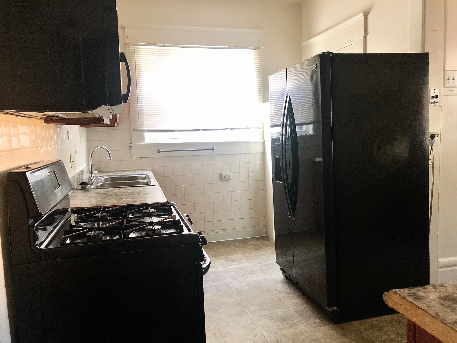 2015 Summit St. kitchen with gas range, double sink, and black side-by-side refrigerator