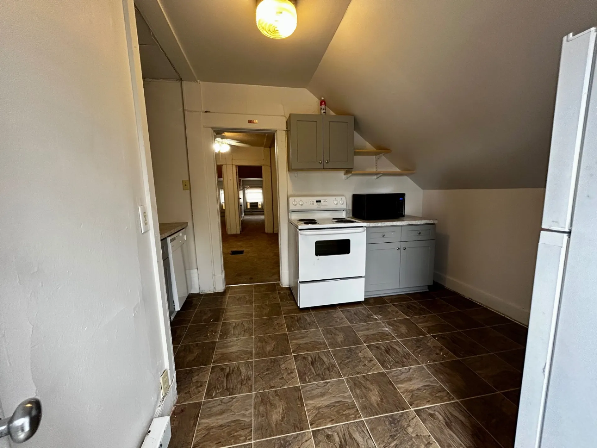 1820 Summit St. wide kitchen view with gray cabinets, open shelving, microwave, and tile floor
