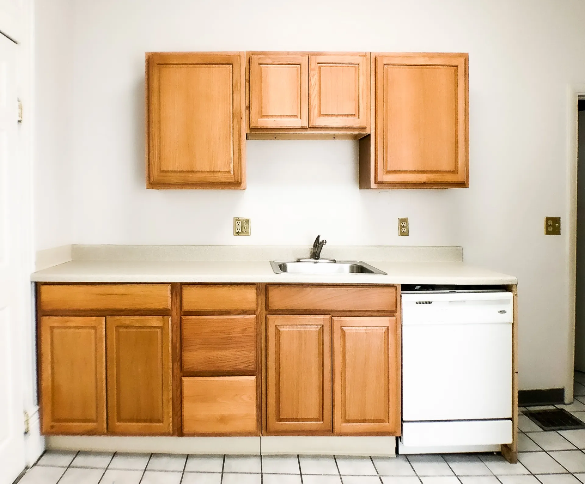 Unit A kitchen cabinetry and sink with solid-surface counters