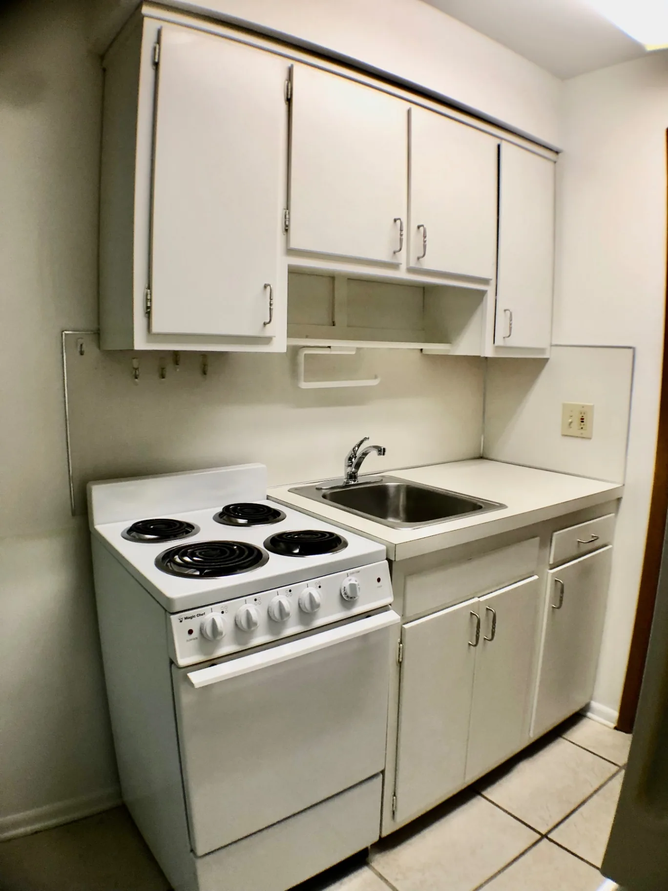 2040 Iuka Ave. 5A kitchen with electric range, stainless sink, and white cabinetry