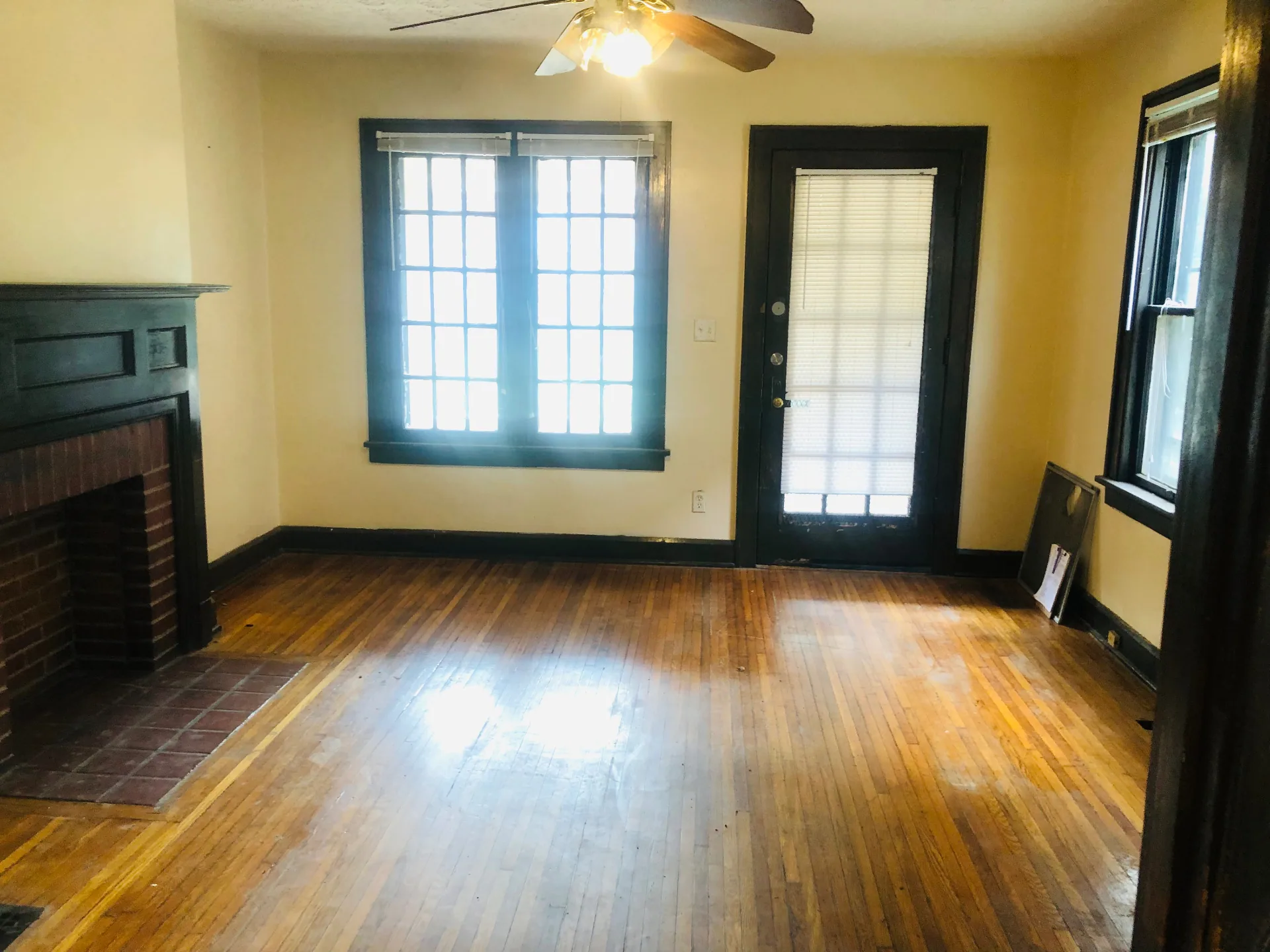 2155 N 4th St. living room with original wood mantel fireplace and side door