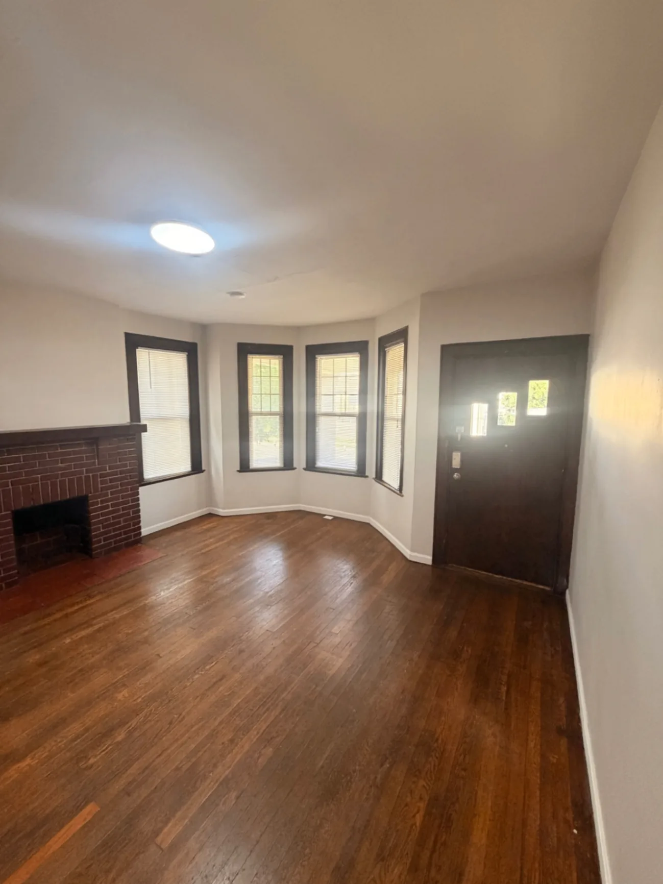 1816 Summit St. living room with bay windows, fireplace, and front entry