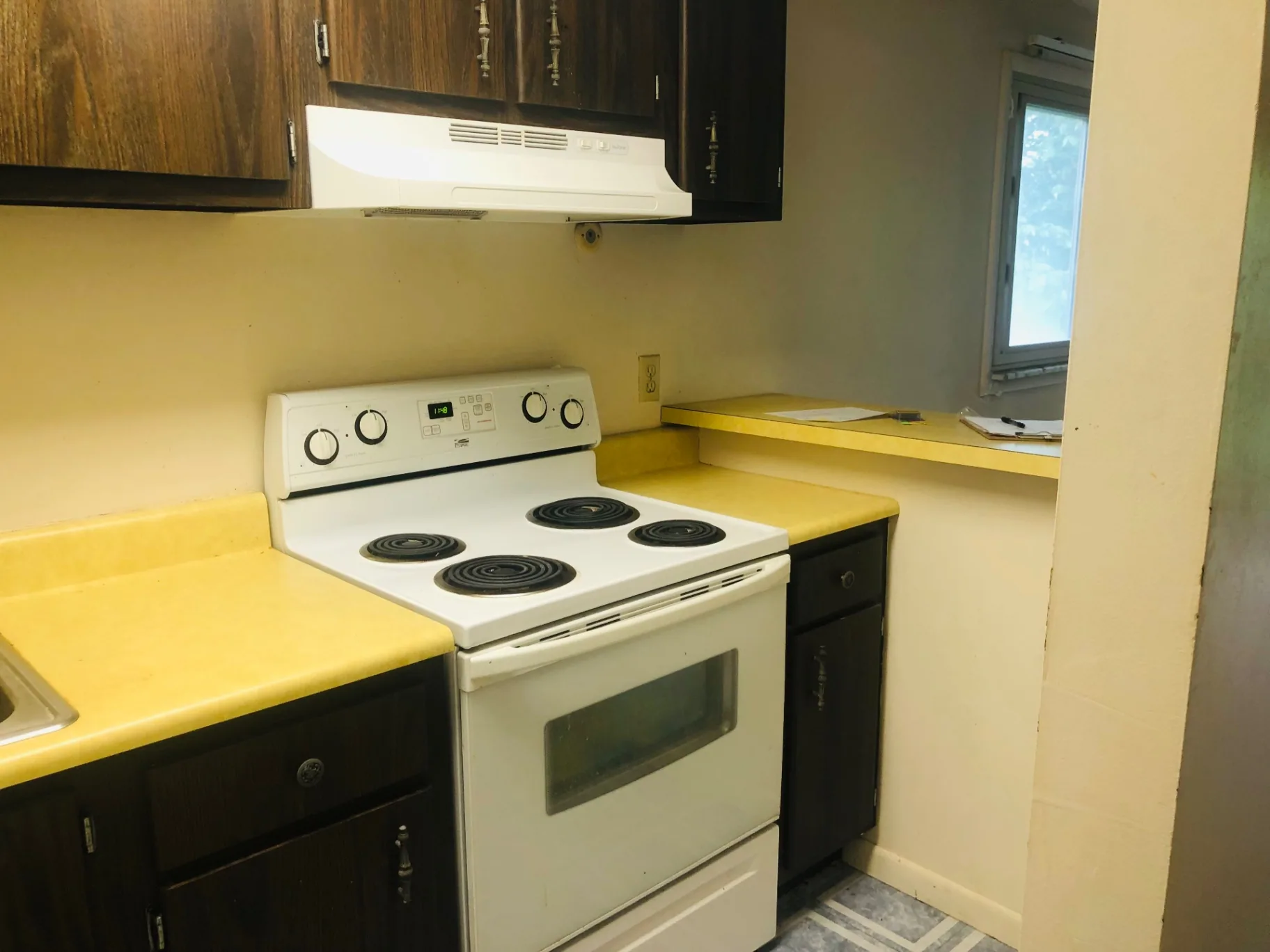 2028 Summit St. kitchen with electric range, wood cabinets, and vent hood