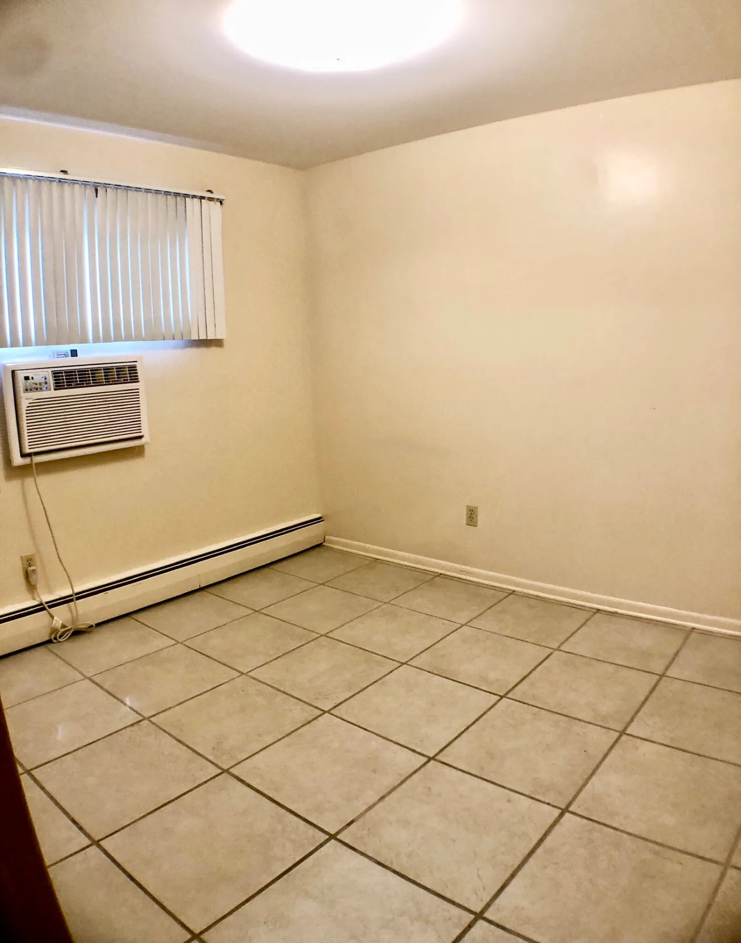 2040 Iuka Ave. 5A bedroom with tile flooring, window AC unit, and baseboard heat