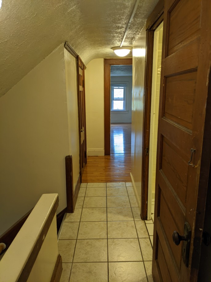 374 C E 14th Ave. upper-level hallway with tile floor, hardwood, and view into bedroom