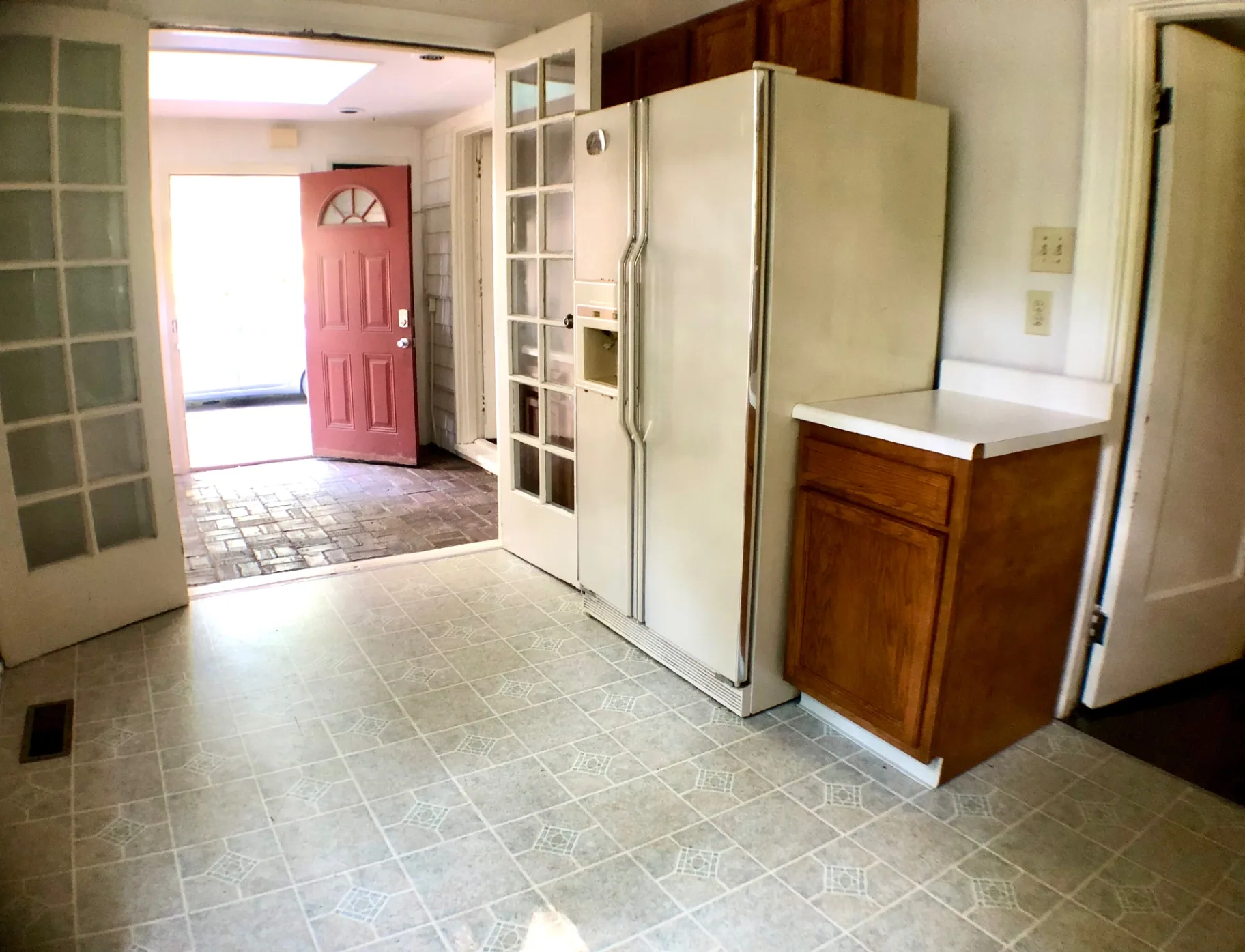 2026 Iuka Ave A kitchen entry with French doors opening toward the brick-floored sunroom